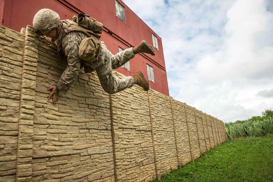 Marine Corps Lance Cpl. Austin Cook jumps over a wall during urban operations training at Boondocker training area on Marine Corps Base Hawaii, Sept. 15, 2015. Cook is a rifleman with Bravo Company, 1st Battalion, 3rd Marine Regiment. U.S. Marine Corps photo by Cpl. Brittney Vito

