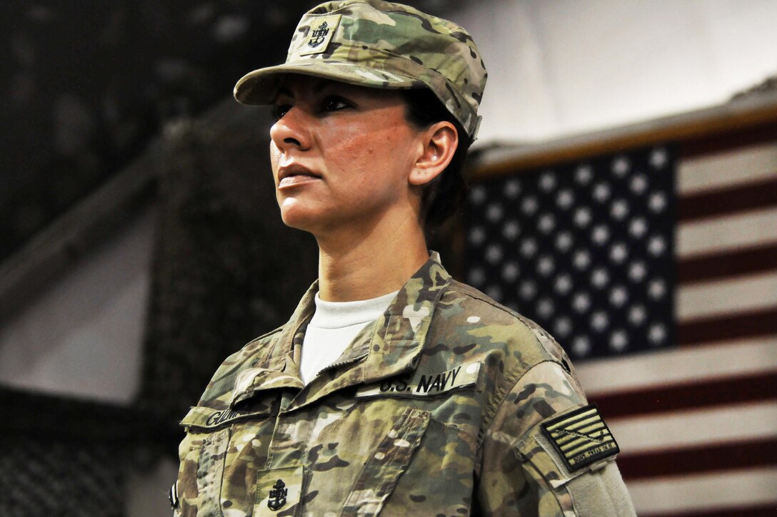 Newly pinned U.S. Navy Chief Jessica Guzman, stands at attention for the Chief Petty Officer Creed during a chief pinning ceremony on Bagram Airfield, Afghanistan, Sept. 16, 2015. Guzman is a hospital corpsman assigned to the Role 3 Multinational Medical Unit based at Kandahar Airfield, is one of seven chief petty officers receiving anchors while serving in Afghanistan. U.S. Navy photo by Lt. Kristine Volk