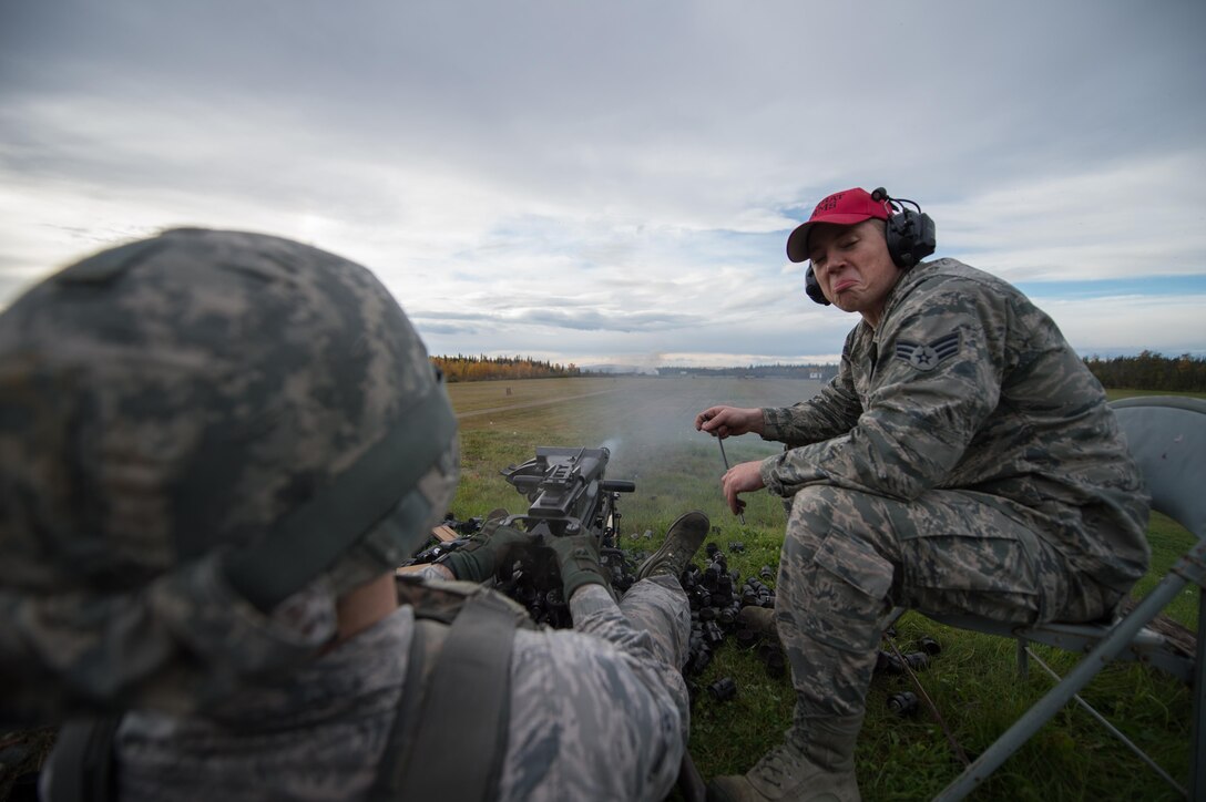 Senior Airman Jordan Thompson, a 168th Alaska Air National Guard combat arms training instructor, nods in approval as Airman 1st Class Nathaniel Kibler, a 354th Security Forces Squadron response force member, fires a Mark 19 grenade launcher  during training Sept. 9, 2015, at Eielson Air Force Base, Alaska. Thompson was leading the training to qualify members of the 354th Security Forces Squadron on the weapon. (U.S. Air Force photo by Staff Sgt. Shawn Nickel/Released)