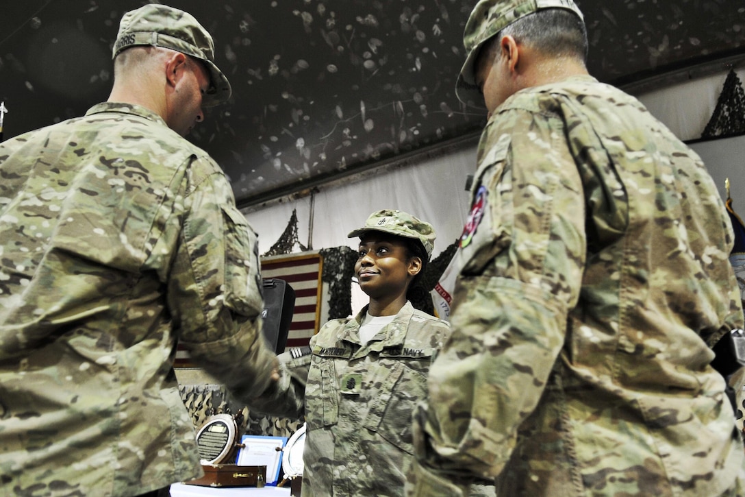 U.S. Navy Chief Ron Harris, left, and U.S. Navy Command Senior Chief James Fyfe, right, congratulate U.S. Navy Chief Petty Officer Jainea Montgomery, center, during a chief pinning ceremony on Bagram Airfield, Afghanistan, Sept. 16, 2015. Harris, Fyfe and Montgomery are assigned to the Role 3 Multinational Medical Unit based at Kandahar Airfield. U.S. Navy photo by Lt. Kristine Volk
