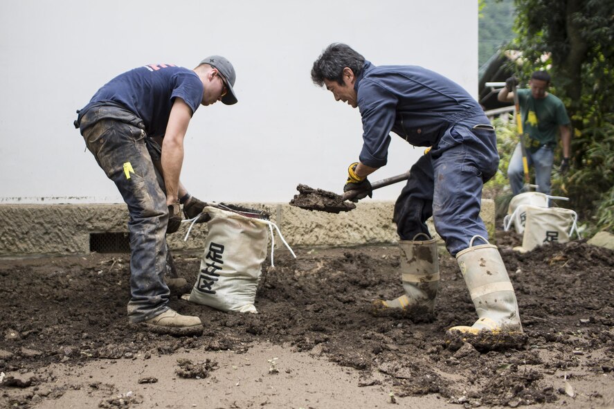 (Left to right) U.S. Air Force Airman 1st Class Zachary Schofield and Masanobu Ishikawa, both from the 374th Civil Engineer Squadron fire department, clean mudflow from a house at Kanuma City, Tochigi Prefecture, Japan, Sept. 15, 2015. Sixty Airmen and civilians from the 374th CES volunteered to help at sites in the Kasono area in support of floods and landslides caused by the heavy rainfall associated with the post-tropical remnant of Tropical Storm Etau, which stalled over eastern Ja-pan, dumping up to 17 inches of rain in 24 hours, from Sept. 10 to Sept. 11. (U.S. Air Force pho-to by Osakabe Yasuo/Released)
