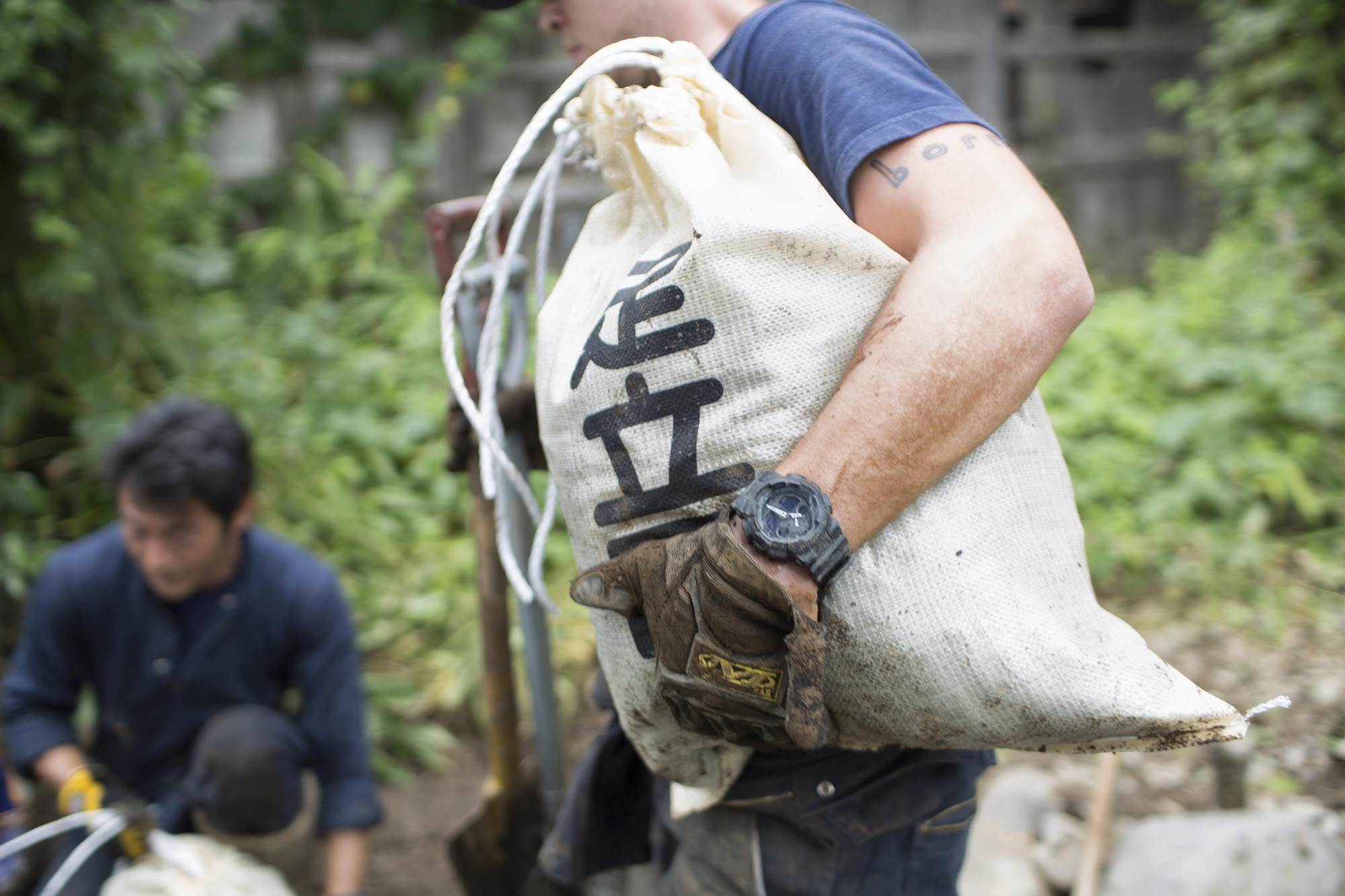 U.S. Air Force Airman 1st Class Zachary Schofield, 374th Civil Engineer Squadron firefighter, carries a bag full of mud after clearing an area of mudflow at Kanuma city, Tochigi Prefecture, Japan, Sept. 15, 2015. Sixty Airmen and civilians from the 374th CES volunteered to help at sites in the Kasono area in support of floods and landslides caused by the heavy rainfall associated with the post-tropical remnant of Tropical Storm Etau, which stalled over eastern Japan, dumping up to 17 inches of rain in 24 hours, from Sept. 10 to Sept. 11. (U.S. Air Force photo by Osakabe Ya-suo/Released)
