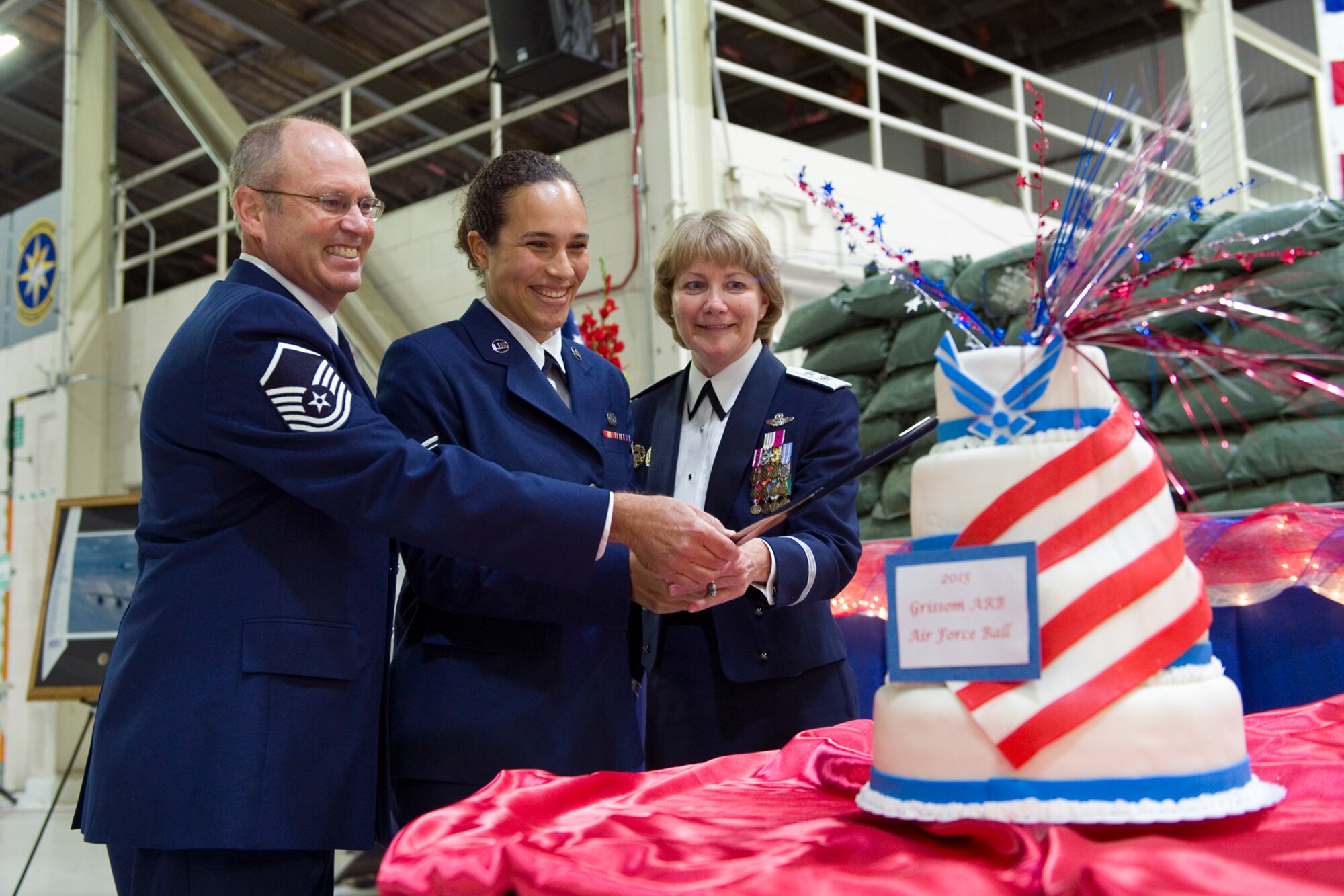Master Sgt. Kerry Vanausdall, 72nd Air Refueling Squadron boom operator, left, Airman 1st Class Kaila Walker, 434th Logistics Readiness Squadron logistic plans apprentice, center, and Maj. Gen. Maryanne Miller, Headquarters U.S. Air Force deputy to the chief of the Air Force Reserve, use a ceremonial sword to cut a cake during the Air Force Ball at Grissom Air Reserve Base, Ind., Sept. 12, 2015. The cake was decorated to commemorate the 70th anniversary to the end of World War II. (U.S. Air Force Photo/Tech. Sgt. Benjamin Mota)