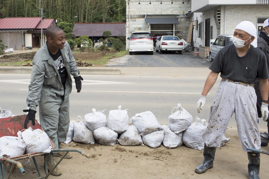 U.S. Air Force Tech. Sgt. Abdul Smith, 374th Civil Engineer Squadron, carries bags full of mud alongside a local resident at Kanuma city, Tochigi Prefecture, Japan, Sept. 15, 2015. Sixty Airmen and civil-ians from the 374th CES volunteered to help at sites in the Kasono area in support of floods and landslides caused by the heavy rainfall associated with the post-tropical remnant of Tropical Storm Etau, which stalled over eastern Japan, dumping up to 17 inches of rain in 24 hours, from Sept. 10 to Sept. 11. (U.S. Air Force photo by Osakabe Yasuo/Released)
