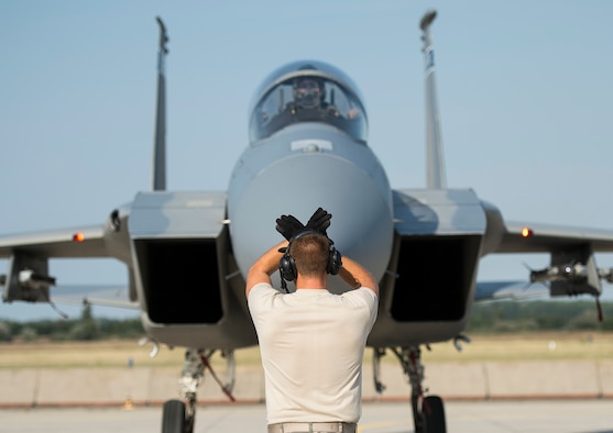 A crew chief from the 123rd Expeditionary Fighter Squadron marshals an F-15 Eagle fighter aircraft at Kecskemet Air Base, Hungary, Sept. 3, 2015. Four Oregon Air National Guard F-15s forward deployed to Hungary from Campia Turzii, Romania, as part of Operation Atlantic Resolve, improving interoperability between NATO allies and ensuring the continued stability of the region. (U.S. Air Force photo/Staff Sgt. Chad Warren)