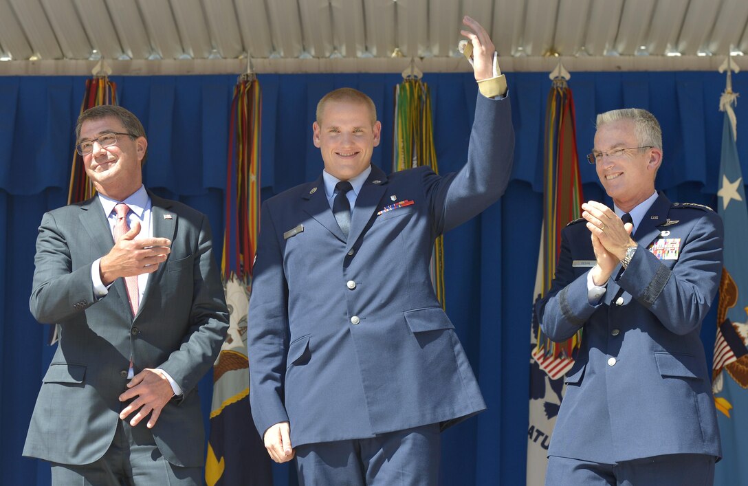 Air Force Airman 1st Class Spencer Stone, waves his still-healing left in the air as Defense Secretary Ash Carter and  Gen. Paul Selva, vice chairman of the Joint Chiefs of Staff, honor him for his role in stopping a gunman on a Paris-bound train outside of Brussels last month on stage during a ceremony at the Pentagon Sept. 17, 2015, honoring him DoD Photo by Glenn Fawcett