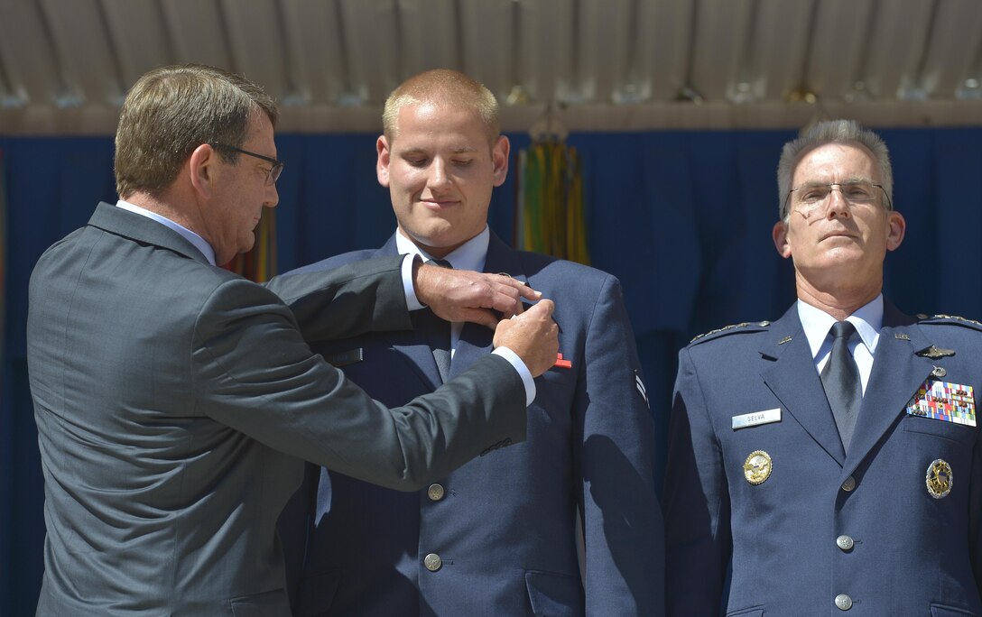 Defense Secretary Ash Carter, left, pins the Airman's Medal on the lapel of Air Force Airman 1st Class Spencer Stone, center and Air Force Gen. Paul Selva, vice chairman of the Joint Chiefs of Staff, stands at attention during a ceremony at the Pentagon Sept. 17, 2015, honoring him for his role in stopping a gunman on a Paris-bound train outside of Brussels. DoD Photo by Glenn Fawcett 
