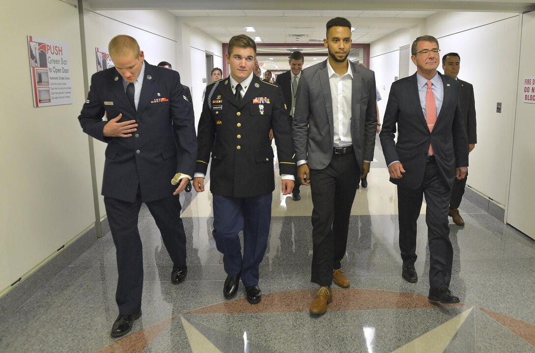 Defense Secretary Ash Carter, right, escorts Air Force Airman 1st Class Spencer Stone, left, Oregon National Guard Specialist Alek Skarlatos, second from left, and civilian Anthony Sadler to an awards ceremony in the Pentagon's courtyard held in their honor for their heroic actions in stopping a gunman on a Paris-bound train outside of Brussels last month, Sept. 17, 2015. DoD Photo by Glenn Fawcett