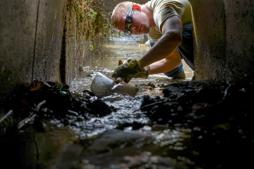U.S. Air Force Airman 1st Class Thomas Smith, 374th Civil Engineer Squadron fire protection, shovels mud from an irrigation system at Kanuma City, Tochigi prefecture, Sept. 15, 2015. Smith and other members of a large volunteer force from Yokota Air Base ventured to Tochigi to assist the locals with mud removal, sand bagging and fixing what was broken during a recent flood and landslide. (U.S. Air Force photo by Staff Sgt. Cody H. Ramirez/Released)