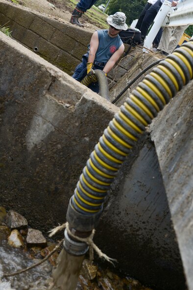 U.S. Air Force Airman 1st Class Jordan Spiceland, 374th Civil Engineer Squadron fire protection, pumps water from a clogged irrigation drain at Kanuma City, Tochigi prefecture, Sept. 15, 2015. Ten consecutive days of rain led to flooding and landslides that damaged much of the local area. More than 60 volunteers from Yokota Air Base ventured to the prefecture to assist with post-damage relief. (U.S. Air Force photo by Staff Sgt. Cody H. Ramirez/Released)