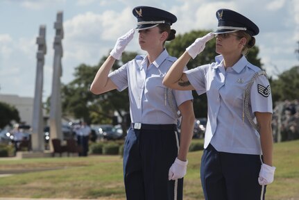 Airman 1st Class Jamie Miller and Staff Sgt. Lydia Chapman, Joint Base San Antonio Honor Guard members, salute the United States Flag during a POW/MIA retreat ceremony Sept. 17, 2015 at JBSA-Randolph. The ceremony, hosted by the 12th Flying Training Wing, caps off a week long homage to POWs and MIAs that also included a POW/MIA breakfast and remembrance run.