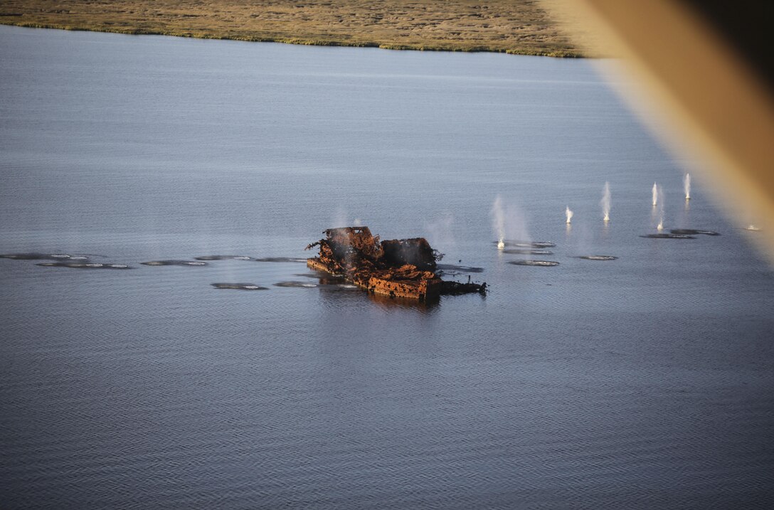 Marines with Marine Medium Tiltrotor Squadron 365 make impact on targets utilizing the GAU-16 .50 caliber machine gun in an MV-22B Osprey in the skies above Piney Island bombing range, Sept. 15, 2015. The crew flew over training area Bombing Target 11 to assault targets resembling a convoy, barge and landing craft. (U.S. Marine Corps photo by Cpl. Paul S. Martinez/Released)