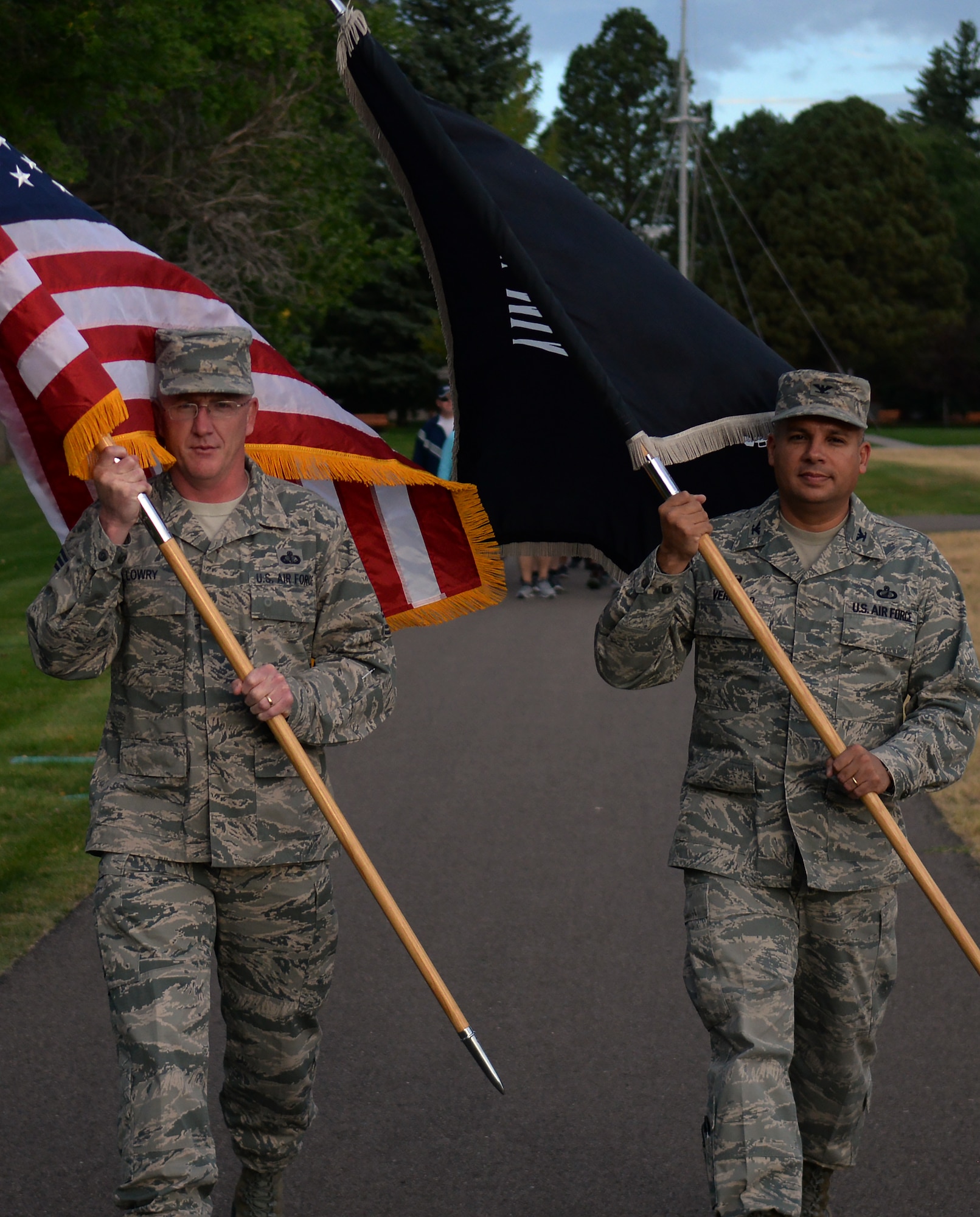 Chief Master Sgt. Clayton Lowry, 90th Force Support Squadron superintendent, carries the American flag while Col. Frank Verdugo, 90th Mission Support Group commander, carries the Prisoners of War/Missing in Action flag Sept. 16, 2015, during the 2015 POW/MIA Memorial Walk and Vigil on the Argonne Parade Field on F.E. Warren Air Force Base, Wyo. Different Airmen volunteers carried the flags from 7:30 a.m. to 4:30 p.m., passing off the flags every half hour. (U.S. Air Force photo by Airman 1st Class Brandon Valle)