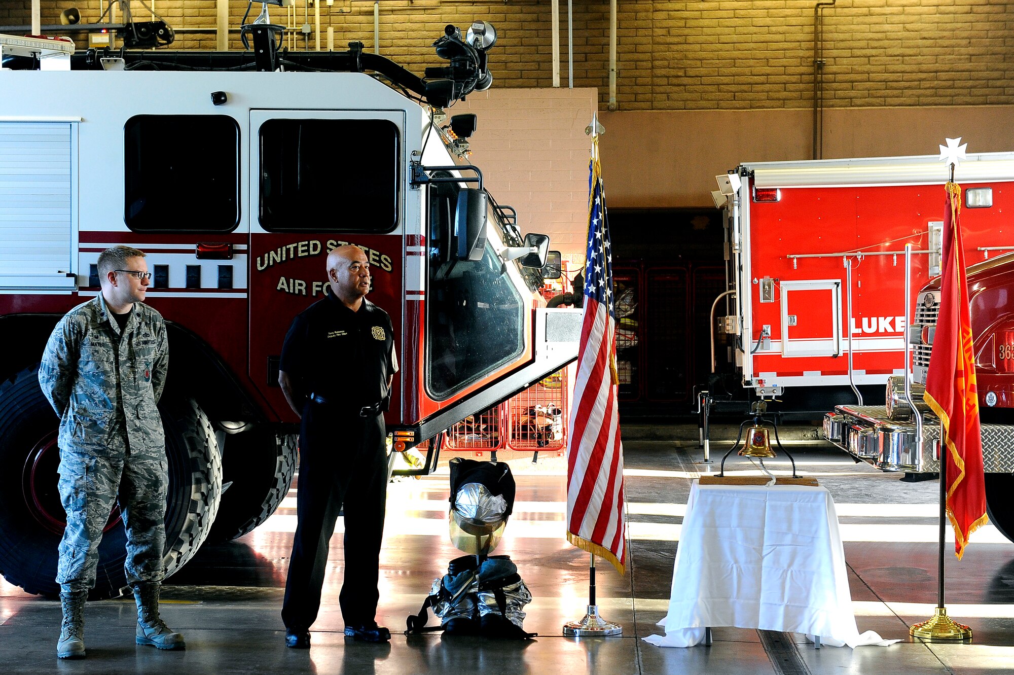 Lt. Col. Gregory Mayer, 56th Civil Engineer Squadron commander, and Anthony Rabonza, 56th CES deputy fire chief, stand by Sept. 11, 2015, while the intercom informs the station of the roll call. This honorary roll call has been done for the past 14 years.  (U.S. Air Force photo by Airman 1st Class Pedro Mota)