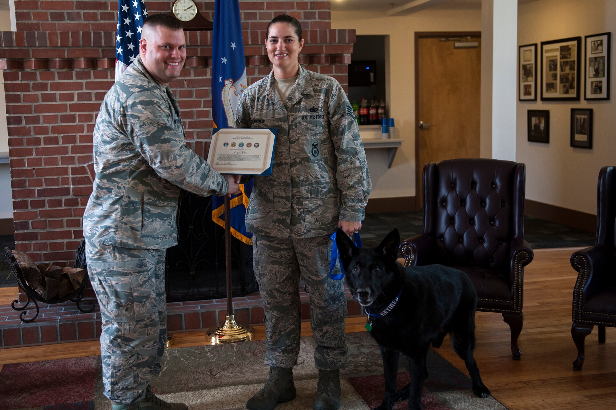 U.S. Air Force Staff Sgt. Renee Mansour, 23d Security Forces Squadron military working dog handler, accepts a service award for MWD Ficko from Maj. Aaron Williams, 23d SFS commander Sept. 15, 2015, at Moody Air Force Base, Ga. Mansour adopted Ficko after working with him for a year and a half. (U.S. Air Force photo by Airman 1st Class Kathleen D. Bryant/Released)

