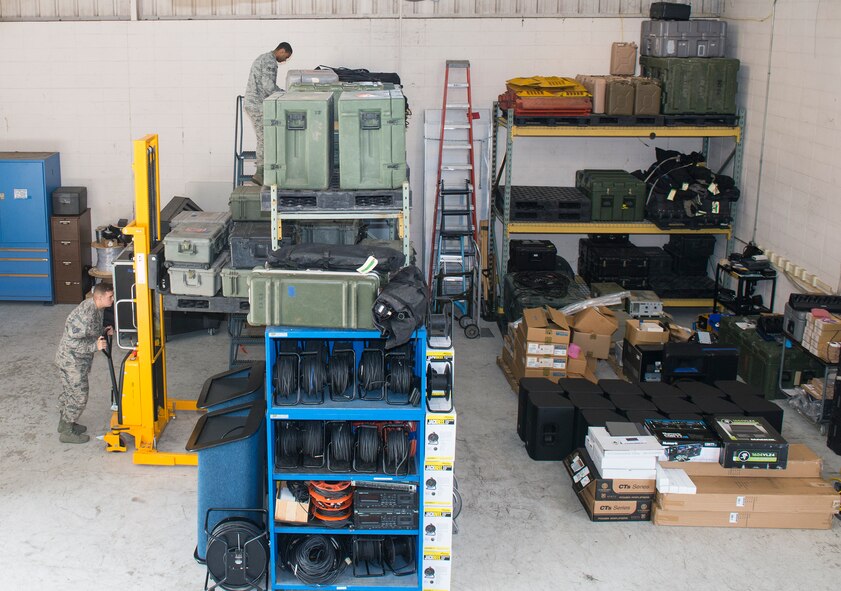 U.S. Air Force Staff Sgt. David Stacho, 23d Communications Squadron radio frequency transmissions supervisor (left), and Senior Airman Dylan Wren, 23d CS radio frequency transmission system technician, retrieve items to set up high-frequency communications Sept. 15, 2015, at Moody Air Force Base, Ga. The tactical radio work center maintains wing command and control systems, operates public address systems for group and wing events, and provides maintenance support to operation units for ground-to-air communication. (U.S. Air Force photo by Airman 1st Class Greg Nash/Released)