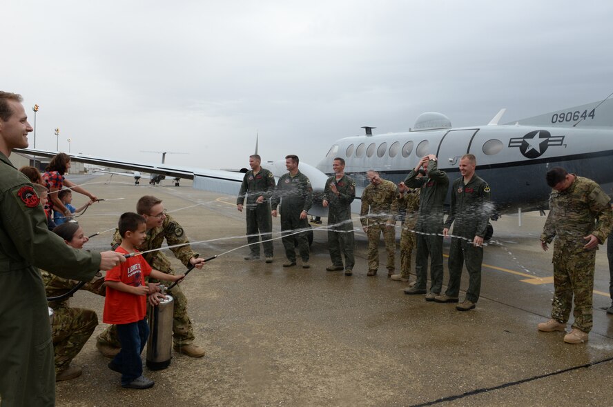 Family and friends spray the aircrew after the final flight of a MC-12W Liberty Sept. 16, 2015, at Beale Air Force Base, California. Although deployed Airmen are still supporting the mission downrange with the Army, the final flight represents Air Combat Command’s last MC-12W sortie. The MC-12W is a medium- to low-altitude, twin-engine turboprop aircraft, which provides intelligence, surveillance and reconnaissance support directly to ground forces. (U.S. Air Force photo by Airman 1st Class Ramon A. Adelan)