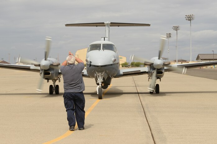 A member of L3 Communications prepares the aircrew of an MC-12W Liberty to takeoff Sept. 16, 2015, at Beale Air Force Base, California. Beale Airmen conducted the aircraft’s final flight with Air Combat Command. The MC-12W is a medium- to low-altitude, twin-engine turboprop aircraft, which provides intelligence, surveillance and reconnaissance support directly to ground forces. (U.S. Air Force photo by Airman 1st Class Ramon A. Adelan)