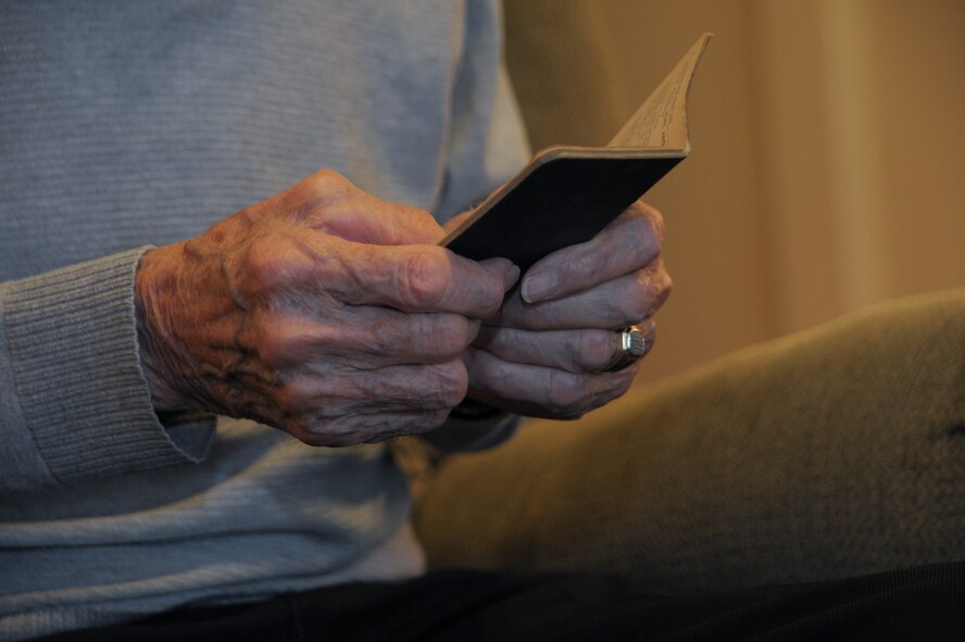U.S. Army Pvt. Tony Gargano, World War II prisoner of war, holds a prayer book at his residence in Tucson, Ariz., Aug. 20, 2015. Gargano carried the little prayer book with him during his time as a POW, tallying each day they marched, in the book, totaling to 30 days. During the march, the POWs had to beg for food, barely surviving off of one meal a day. (U.S. Air Force photo by Airman 1st Class Ashley N. Steffen/Released)