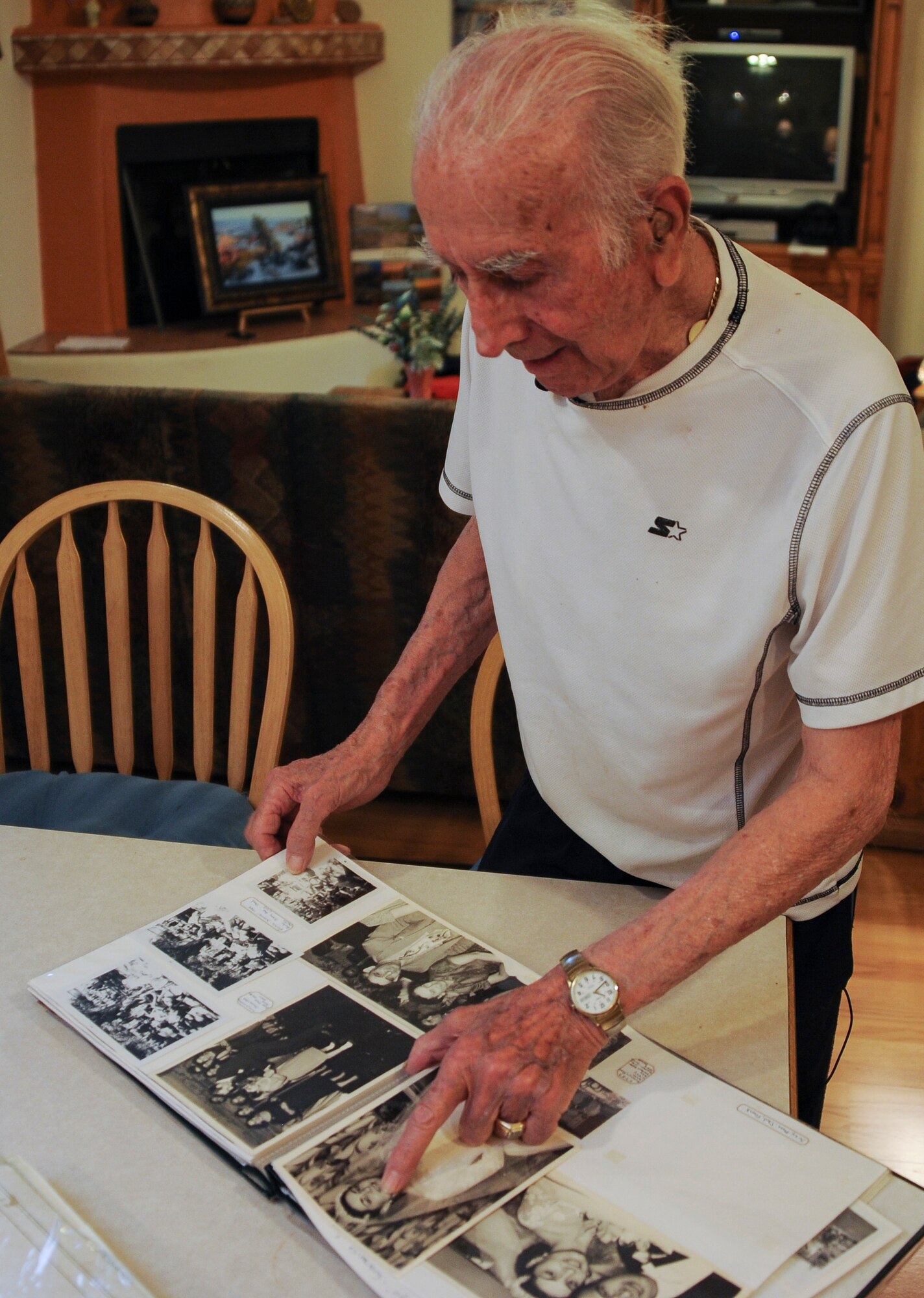 U.S. Army Pvt. Tony Gargano, World War II prisoner of war, points to a family member in his photo album at his residence in Tucson, Ariz., Sept. 10, 2015. Gargano was one of six men in his family to serve during WWII. (U.S. Air Force photo by Airman 1st Class Ashley N. Steffen/Released) 