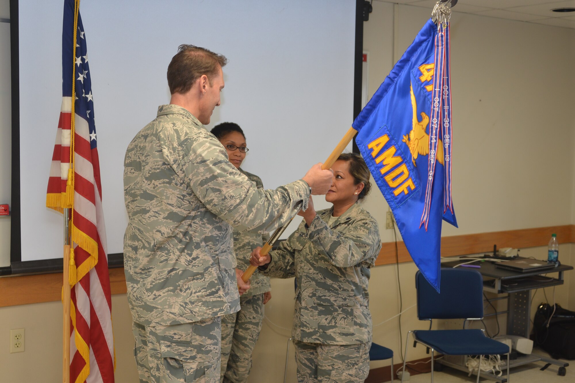 Col. David Piffarerio, 477th Fighter Group commander, presents the 477th Aerospace Medical Flight guidon to Lt. Col. Gina Gorski, the new 477th AMDF commander, during an assumption of command ceremony, Sept.  13. Before the assumption of command ceremony Gorski was promoted to lieutenant colonel. (U.S. Air Force Photo/ Tech. Sgt. Dana Rosso) 