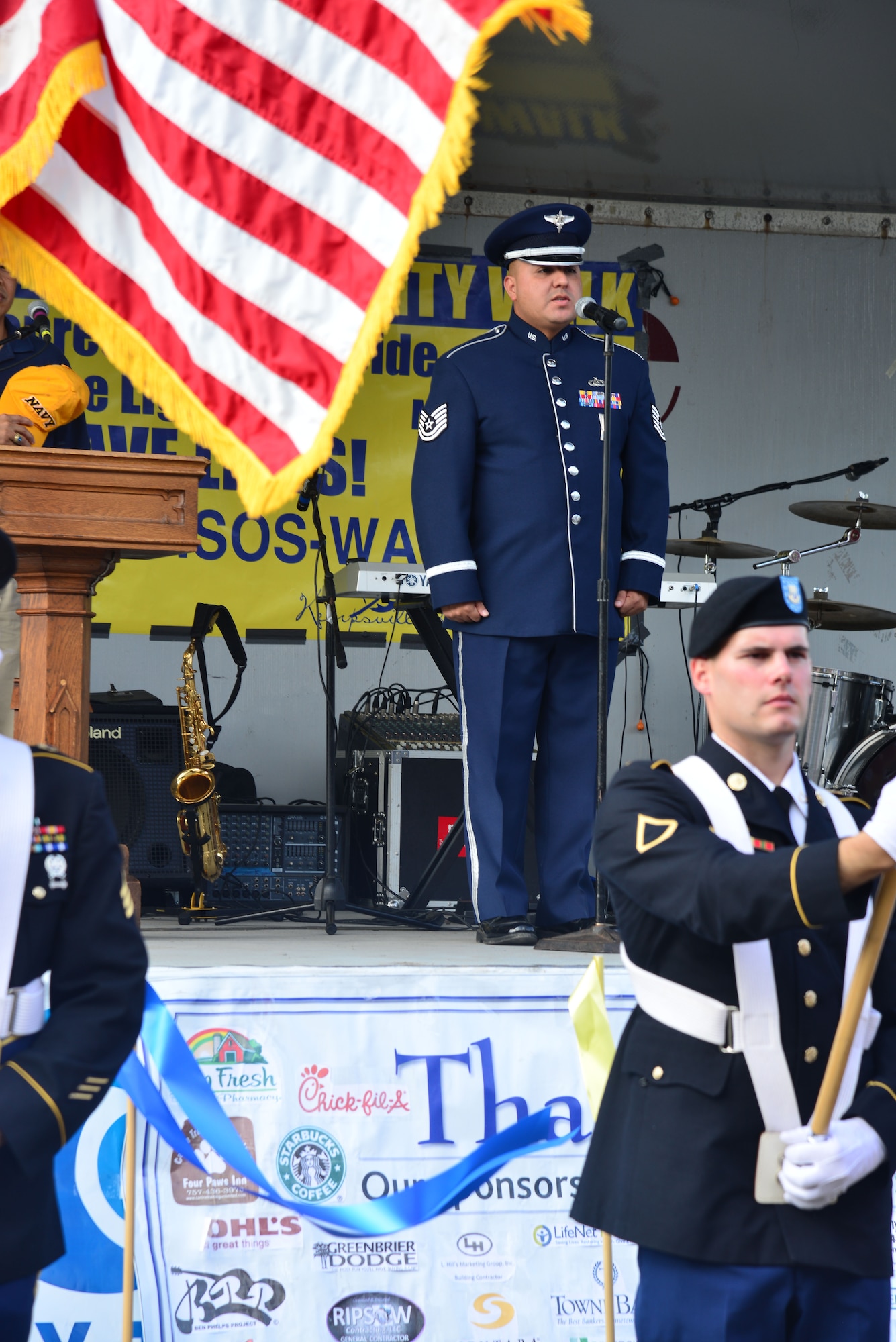 U.S. Air Force Tech. Sgt. Richard Vasquez, U.S. Air Force Heritage of America Band vocalist, sings the National Anthem at the start of the 10th annual Out of the Darkness Community Walk in Virginia Beach, Va., Sept. 12, 2015. As Vasquez sang the National Anthem, members of the Joint Service Color Guard presented the nation’s colors and the flags of each U.S. military branch. (U.S. Air Force photo by Senior Airman Aubrey White/Released)