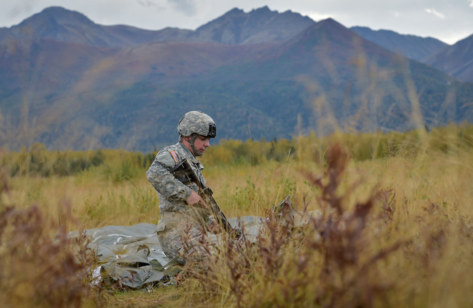 Army Sgt. Jeremy Twomey assigned to C Company, 6th Brigade Engineer Battalion, 4th Infantry Brigade Combat Team (Airborne), 25th Infantry Division, U.S. Army Alaska, Riverside Calif., loads his weapon after conducting an airborne operation with USARAK Commanding General Army Maj. Gen. Bryan Owens from CH-47 Chinook helicopters over Malemute drop zone on Joint Base Elmendorf-Richardson, Alaska, Sept. 10, 2015. USARAK is a central component to the Army’s rebalance to the Pacific, providing two fully mission-ready Brigade Combat Teams ready to position unit elements anywhere across the Pac-Rim within 18 hours notice, and is uniquely positioned within nine-hours flight time from 90 percent of the world’s most highly-populated regions. (U.S. Air Force photo/Justin Connaher)