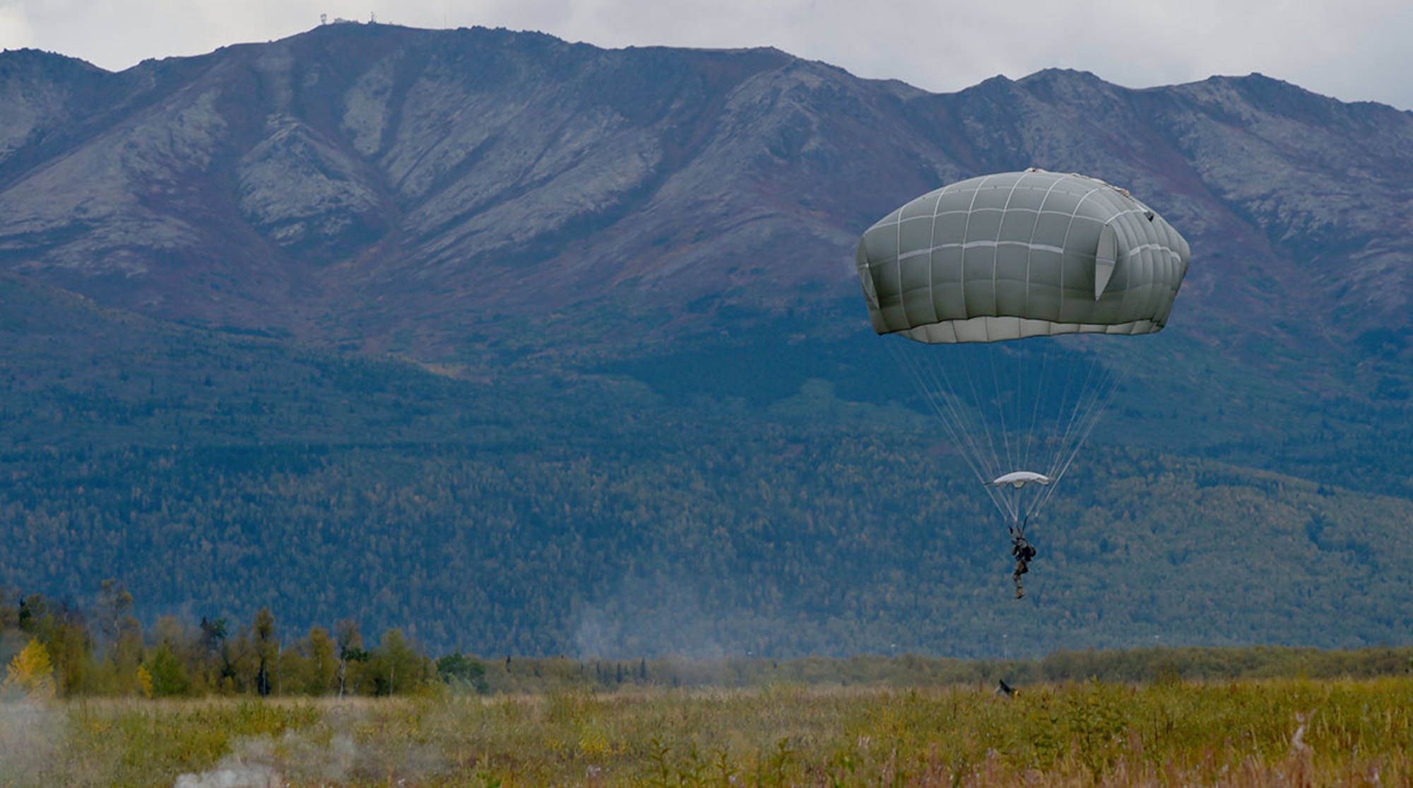 A Soldier assigned to U.S. Army Alaska prepares to land while conducting an airborne operation with USARAK Commanding General Army Maj. Gen. Bryan Owens from CH-47 Chinook helicopters over Malemute drop zone on Joint Base Elmendorf-Richardson, Alaska, Sept. 10, 2015.  USARAK is a central component to the Army’s rebalance to the Pacific, providing two fully mission-ready Brigade Combat Teams ready to position unit elements anywhere across the Pac-Rim within 18 hours notice, and is uniquely positioned within nine-hours flight time from 90 percent of the world’s most highly-populated regions. (U.S. Air Force photo/Justin Connaher)