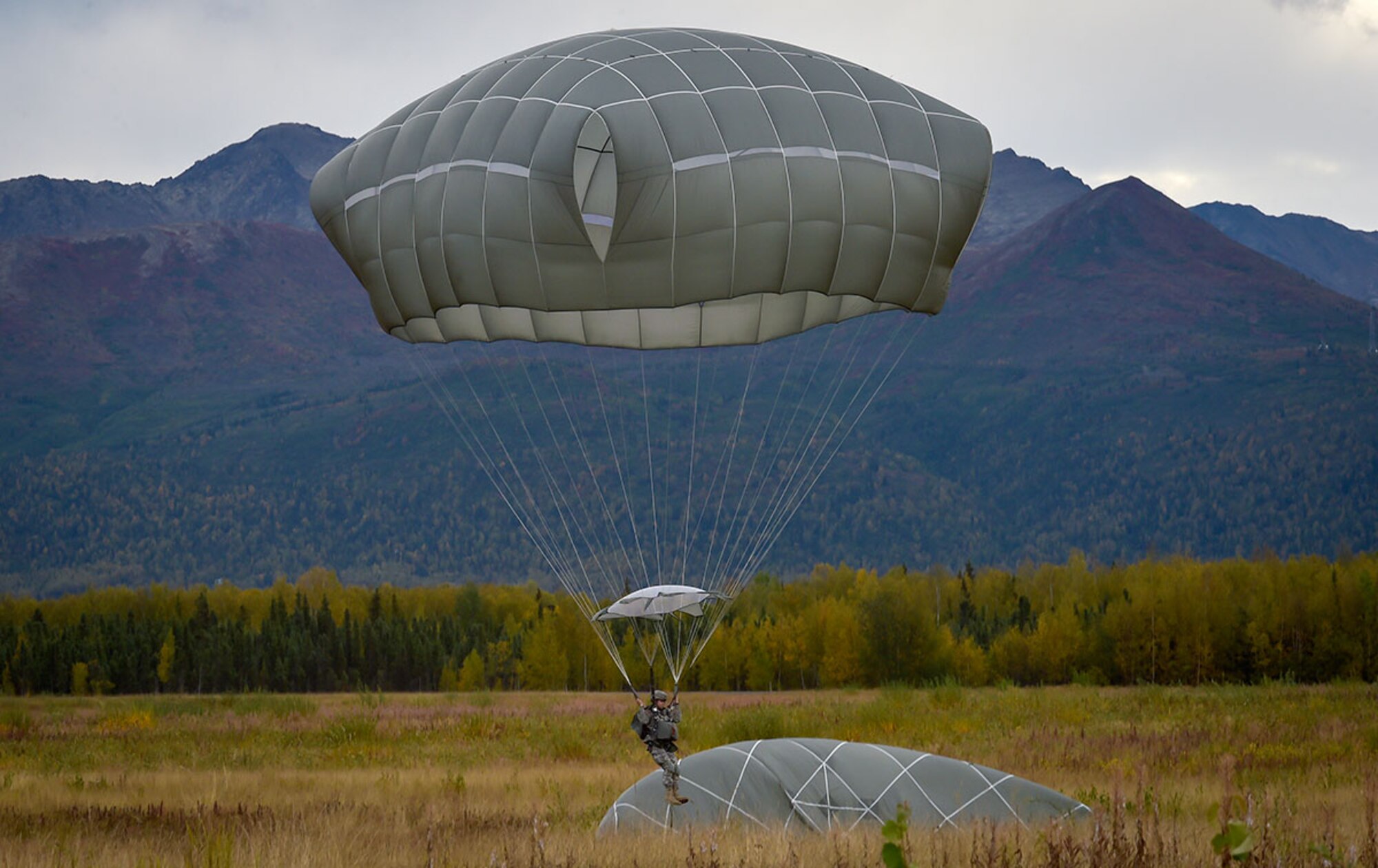 A Soldier assigned to U.S. Army Alaska prepares to land while conducting an airborne operation with USARAK Commanding General Army Maj. Gen. Bryan Owens from CH-47 Chinook helicopters over Malemute drop zone on Joint Base Elmendorf-Richardson, Alaska, Sept. 10, 2015.  USARAK is a central component to the Army’s rebalance to the Pacific, providing two fully mission-ready Brigade Combat Teams ready to position unit elements anywhere across the Pac-Rim within 18 hours notice, and is uniquely positioned within nine-hours flight time from 90 percent of the world’s most highly-populated regions. (U.S. Air Force photo/Justin Connaher)