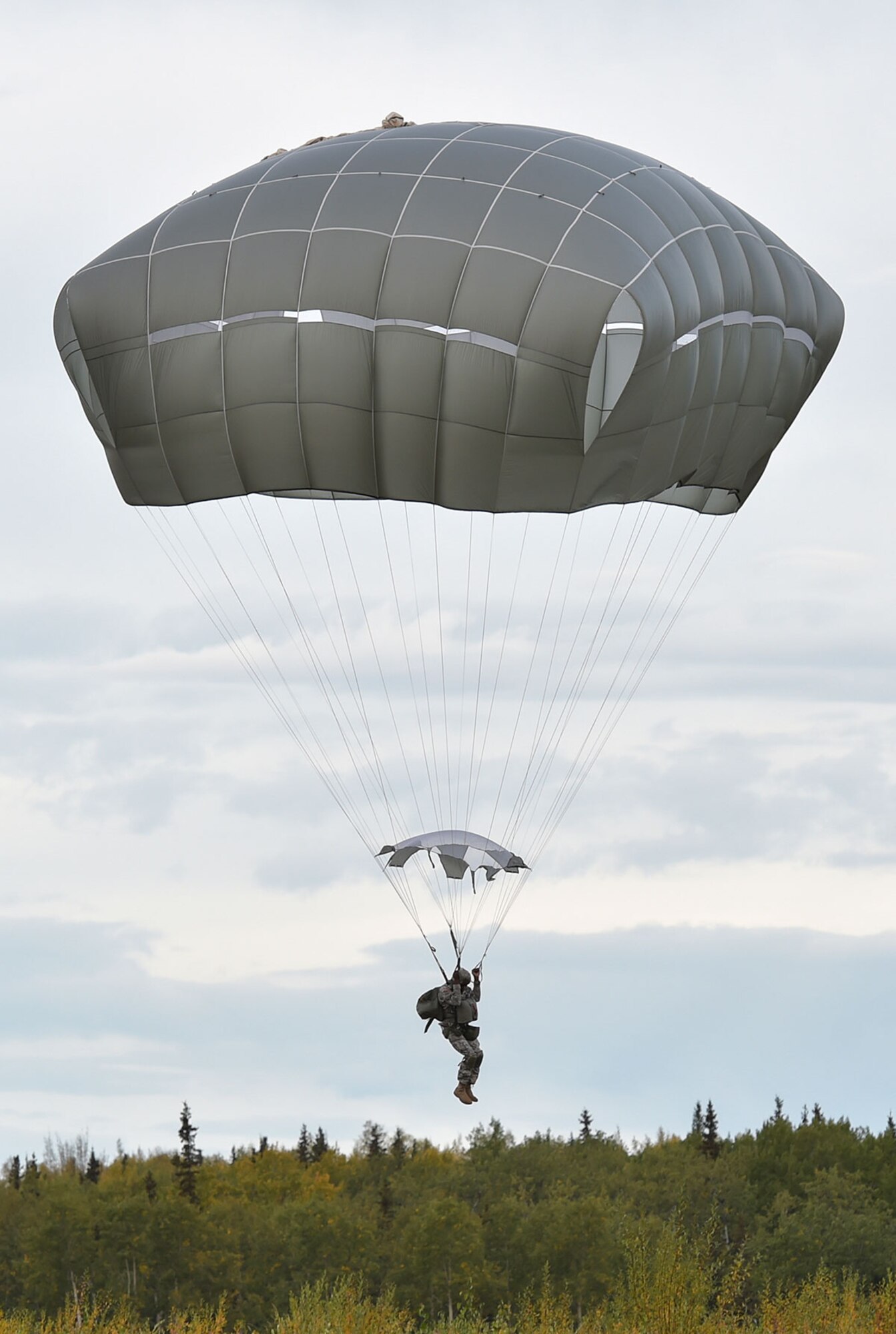 A Soldier assigned to U.S. Army Alaska prepares to land while conducting an airborne operation with USARAK Commanding General Army Maj. Gen. Bryan Owens from CH-47 Chinook helicopters over Malemute drop zone on Joint Base Elmendorf-Richardson, Alaska, Sept. 10, 2015.  USARAK is a central component to the Army’s rebalance to the Pacific, providing two fully mission-ready Brigade Combat Teams ready to position unit elements anywhere across the Pac-Rim within 18 hours notice, and is uniquely positioned within nine-hours flight time from 90 percent of the world’s most highly-populated regions. (U.S. Air Force photo/Justin Connaher)