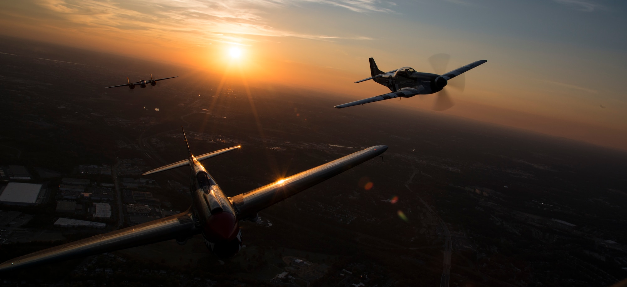 A P-40 Warhawk, P-51 Mustang and a B-25 Mitchell fly over Joint Base Bolling-Anacostia, Washington, D.C., during a Military Tattoo on base Sept. 16, 2015. The “Warbirds flight”, which also consisted of two B-25 Mitchells and two P-40 Warhawks. (U.S. Air Force photo by Airman 1st Class Philip Bryant/Released)