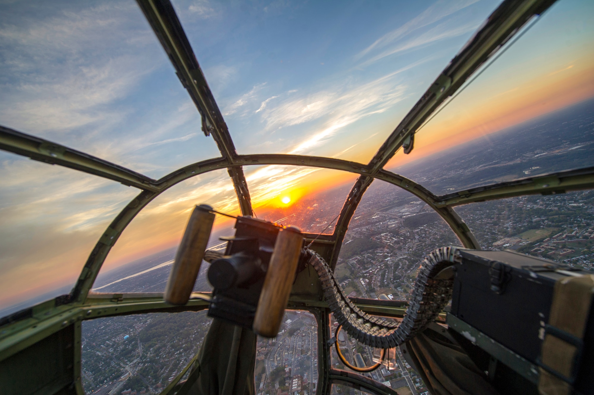 A sunset is seen through the nose of a B-25 Mitchell during a Military Tattoo held at Joint Base Anacostia-Bolling, Washington, D.C., Sept. 16, 2015. The “Warbird flight” consisted of two B-25 Mitchells, two P-40 Warhawks and a P-51 Mustang. (U.S. Air Force photo/Airman 1st Class Ryan J. Sonnier)