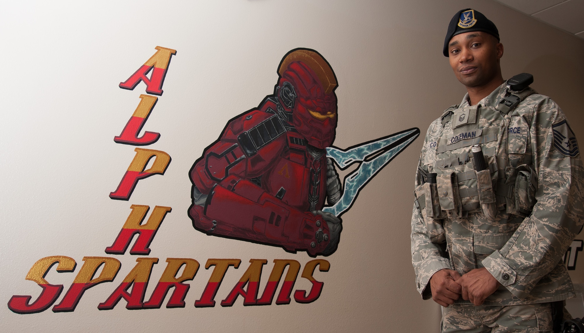 Master Sgt. Horace Coleman IV, 30th Security Forces Squadron flight chief, stands next to a mural depicting his Alpha Flight mascot, Sept. 14, 2015, Vandenberg Air Force Base, Calif. Coleman was announced as the 2015 Lance P. Sijan award winner for Air Force Space Command on Sept. 2, 2015. (U.S. Air Force photo by Michael Peterson)