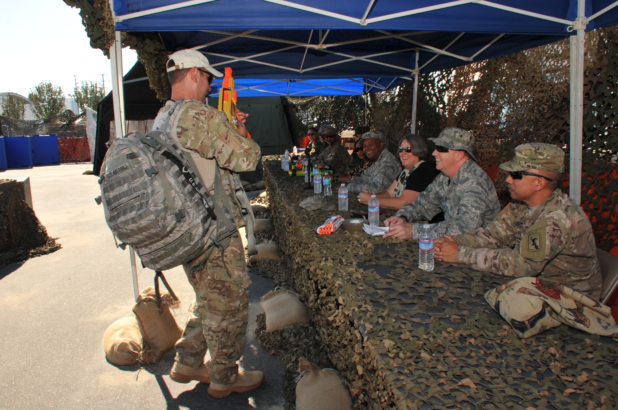 Senior Master Sgt. Steven Shulski, Space and Missile Systems Center 1st Sergeant performs a “weapons check” of a NERF rifle as one of the official Sergeants-at-arms under the watchful gaze of Lt. Gen. Samuel Greaves, SMC commander and Air Force Program Executive Officer for Space (center), Maj. Gen. Robert McMurry, SMC vice commander, serving as president of the Mess, and California National Guard Command Sgt. Maj. Ron Cabrera, one of the honored guest speakers during the SMC Combat Dining-Out held at Los Angeles Air Force Base in El Segundo, Calif. (U.S. Air Force photo/Sarah Corrice)