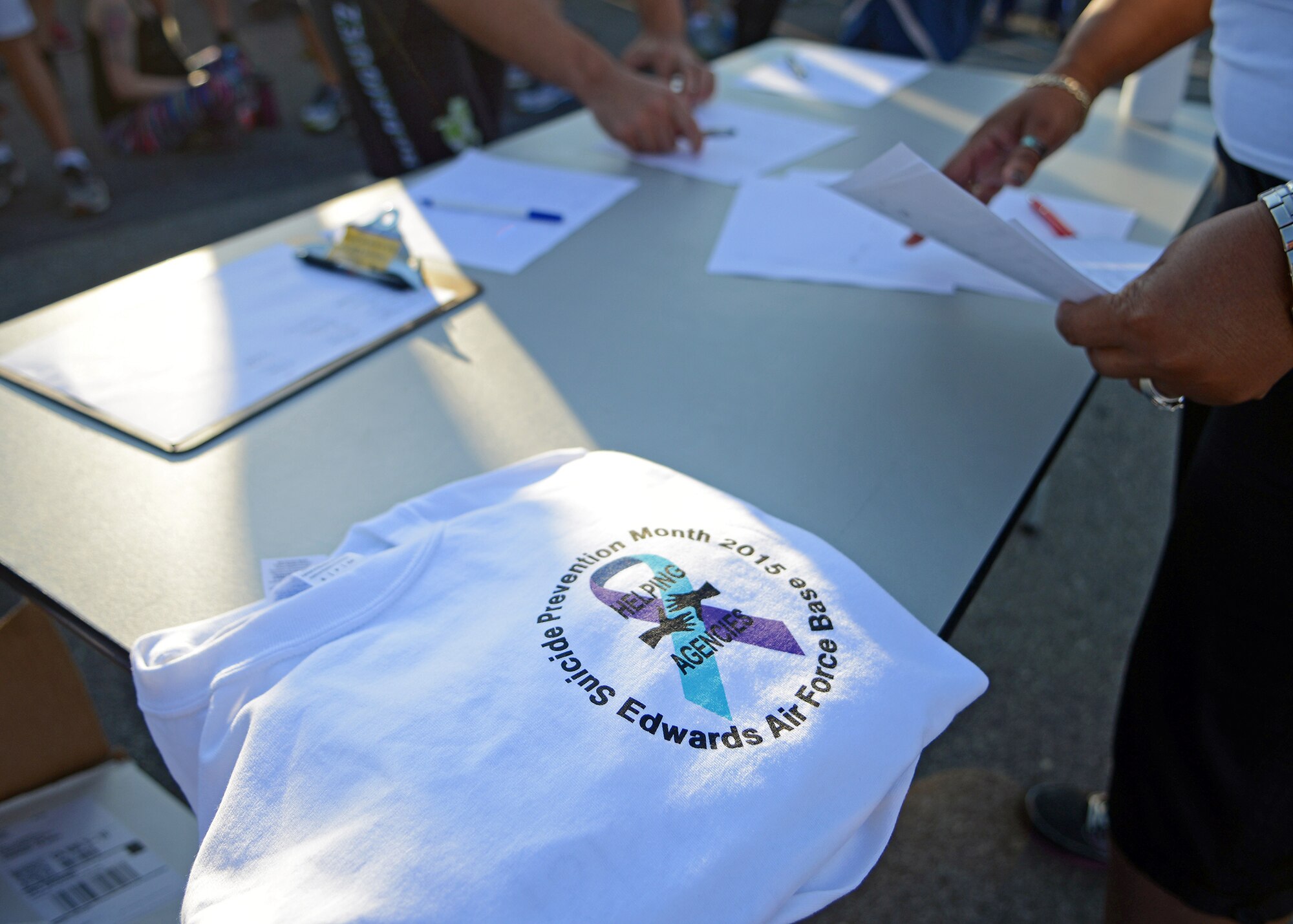 As part of the Suicide Prevention Month 5k run held Sept. 11 at the Rosburg Fitness Center, participants received a free Suicide Prevention-themed t-shirt for participation. T-shirts given out during the event will be used, later in the month, to receive free bowling, discounted golf and discounted meals. (U.S. Air Force photo by Jet Fabara)