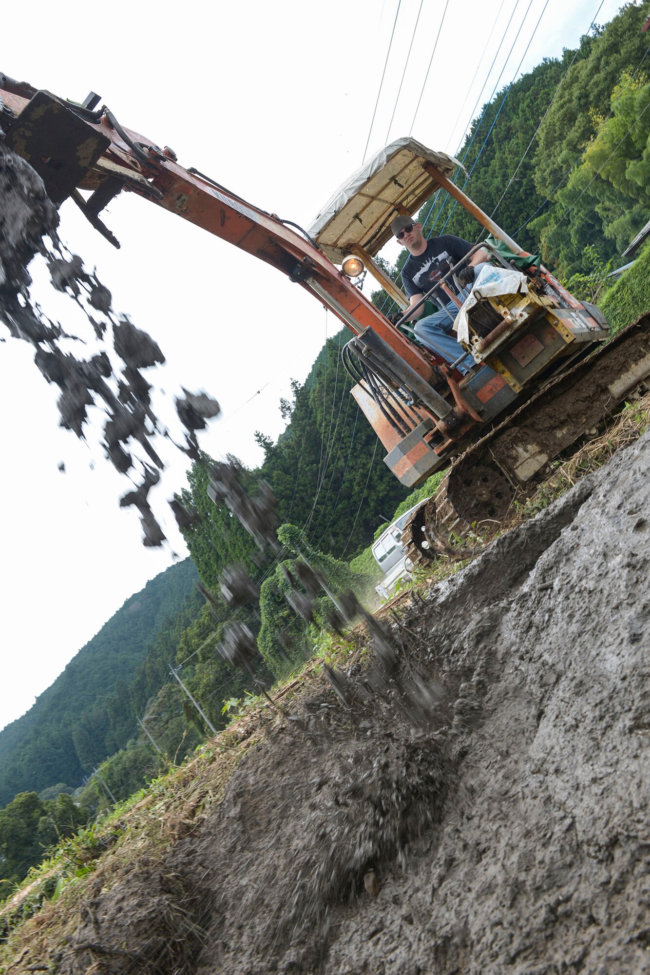 Tech. Sgt. Marshall Johnston, 374th Civil Engineer Squadron structures craftsman,
drops mud on the side of an irrigation creek at Kanuma City, Tochigi prefecture, Japan,
Sept. 15, 2015. Johnston used mud taken from a clogged irrigation drain to fix an
eroded creek wall that was leaking into a farmer's field. More than 60 volunteers from
Yokota Air Base ventured to the prefecture to assist with post-flood and landslide relief.
(U.S. Air Force photo by Staff Sgt. Cody H. Ramirez/Released)