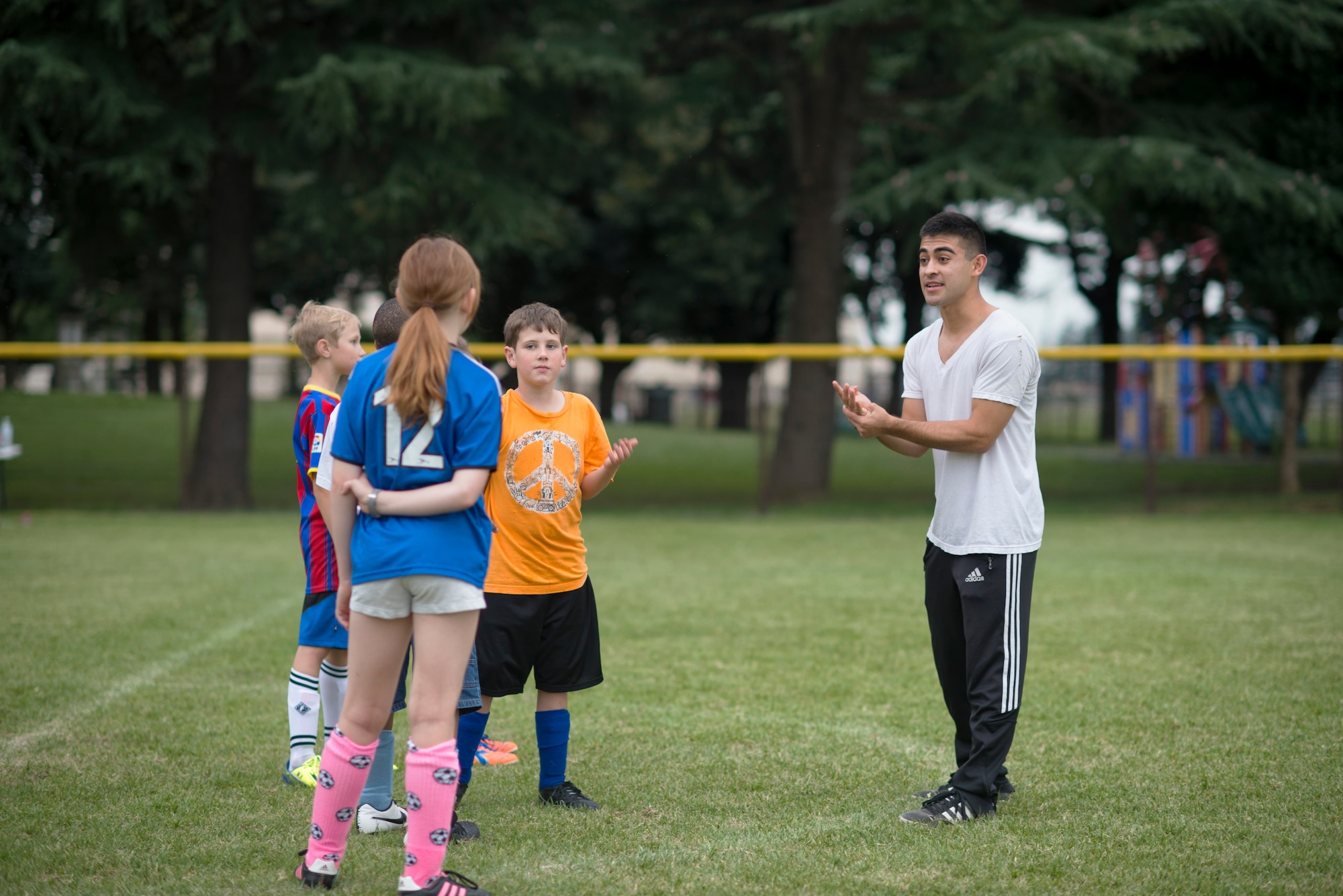 Airman 1st Class Tomasz Barba, volunteer soccer coach, discusses the importance of communication with youth soccer participants at Yokota Air Base, Japan, Sept. 15, 2015. Barba, a rookie coach, asked his players to help him out by providing any input they had regarding his style. (U.S. Air Force photo by Airman 1st Class Delano Scott/Released)