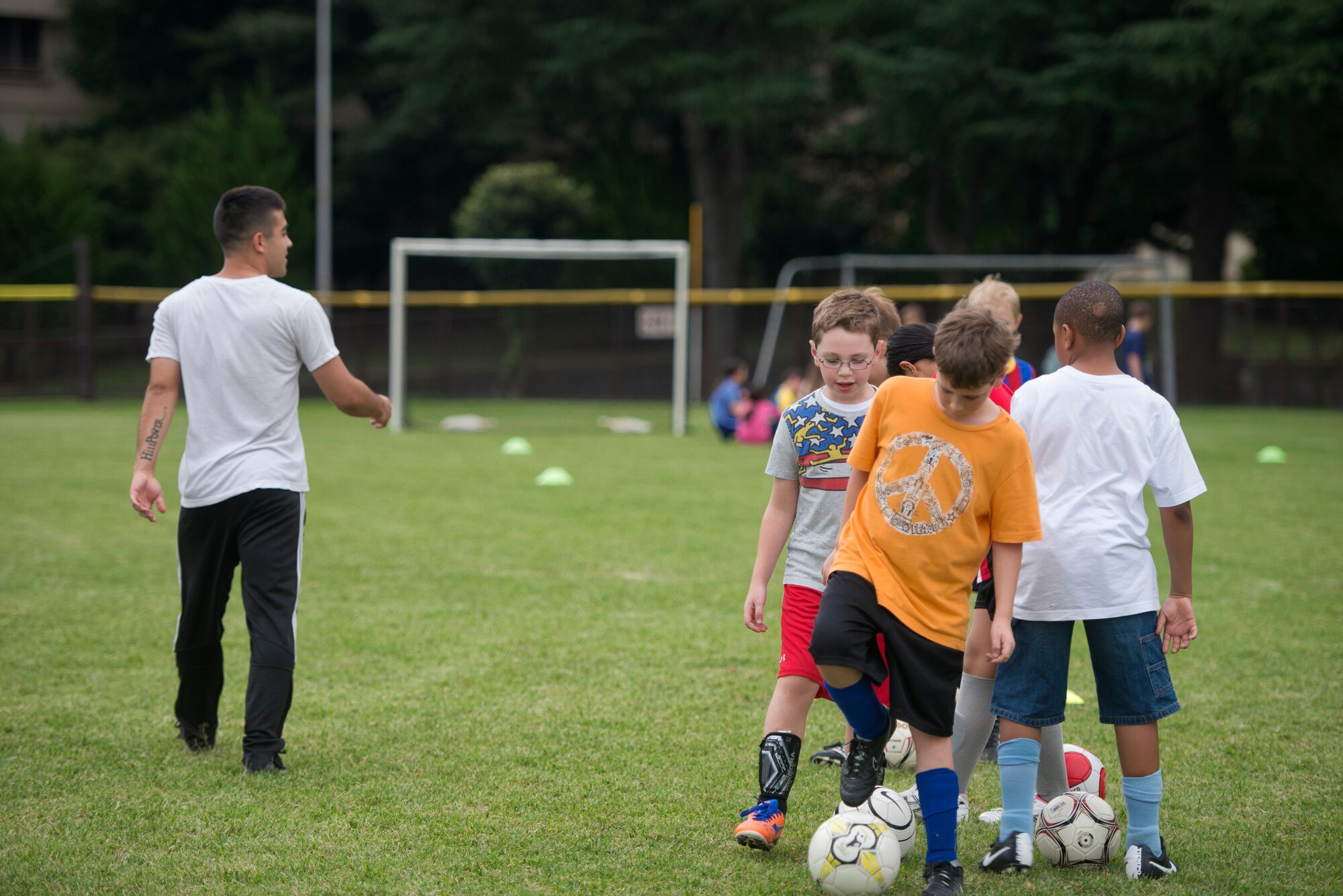 Airman 1st Class Tomasz Barba, volunteer soccer coach, instructs youth soccer participants about their next drill at Yokota Air Base, Japan, Sept. 15, 2015. Outside of developing soccer skills, Barba said that he also tries to instill the value of respect into his players. (U.S. Air Force photo by Airman 1st Class Delano Scott/Released)