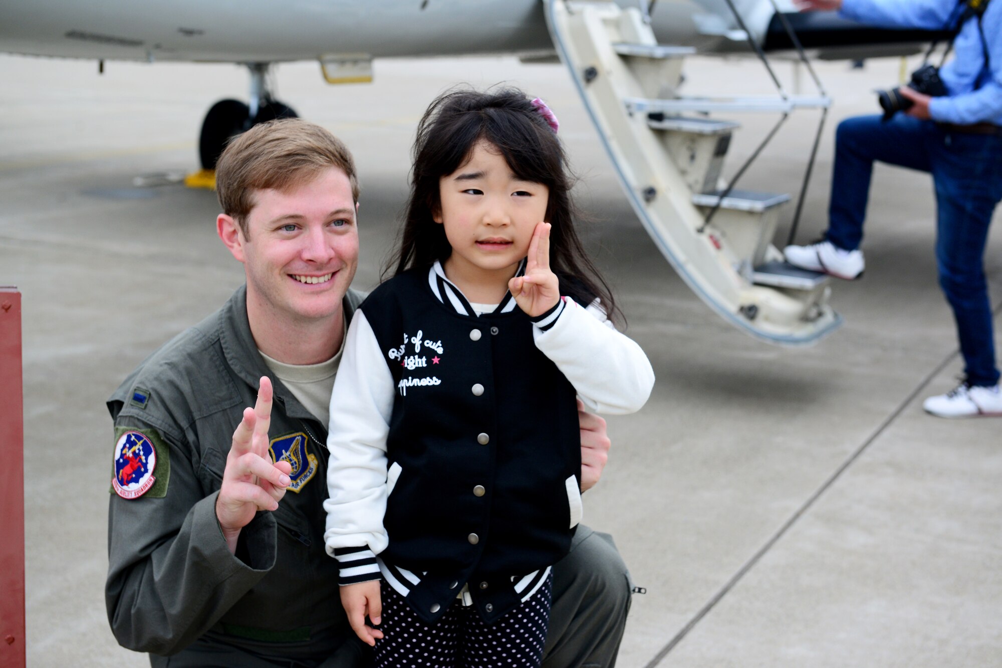 U.S. Air Force 1st Lt. Jonathan Primeaux 459th Airlift Squadron C-12 Huron pilot, poses with a child at the Misawa Air Festival Sept. 13, 2015. Airmen with the 459th Airlift Squadron and 36th Airlift Squadron from Yokota Air Base participated in the Air Festival interacting with and teaching the local community about the aircraft. (U.S. Air Force photo by Tech. Sgt. Melissa Mekpongsatorn/Released)