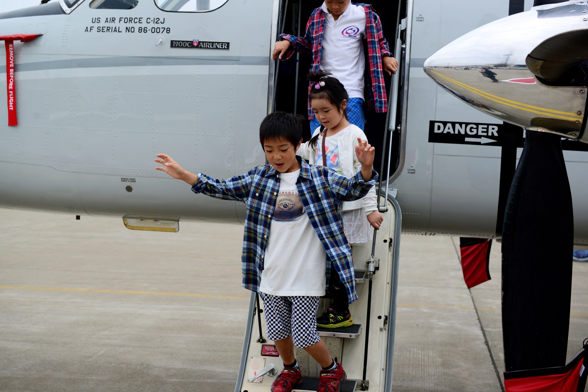 Children hop off the steps of a the C-12 Huron at Misawa Air Festival Sept. 13, 2015. The festival featured more than 30 static displays of US, Australian and Japanese aircraft. (U.S. Air Force photo by Tech. Sgt. Melissa Mekpongsatorn/Released) 
