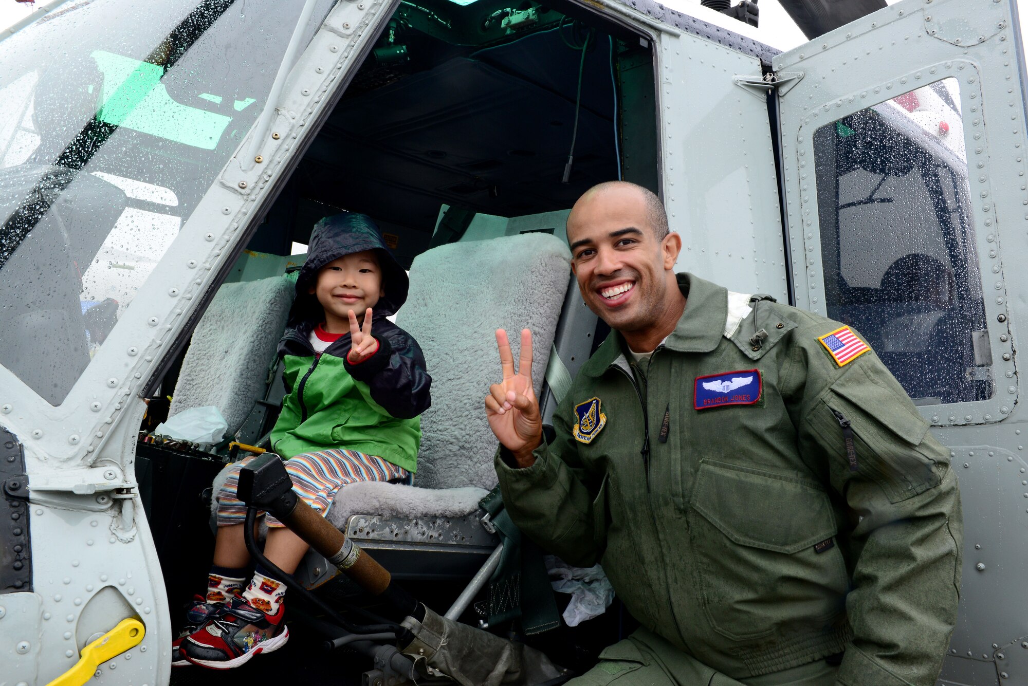 U.S. Air Force Capt. Brandon Jones 459th Airlift Squadron UH-1N Iroquois pilot, poses with a young festival attendee at Misawa Air Base, Japan, Sept. 13, 2015. Airmen with the 459th Airlift Squadron and 36th Airlift Squadron from Yokota Air Base participated in the Misawa Air Festival interacting with and teaching the local community about the aircraft. (U.S. Air Force photo by Tech. Sgt. Melissa Mekpongsatorn/Released) 