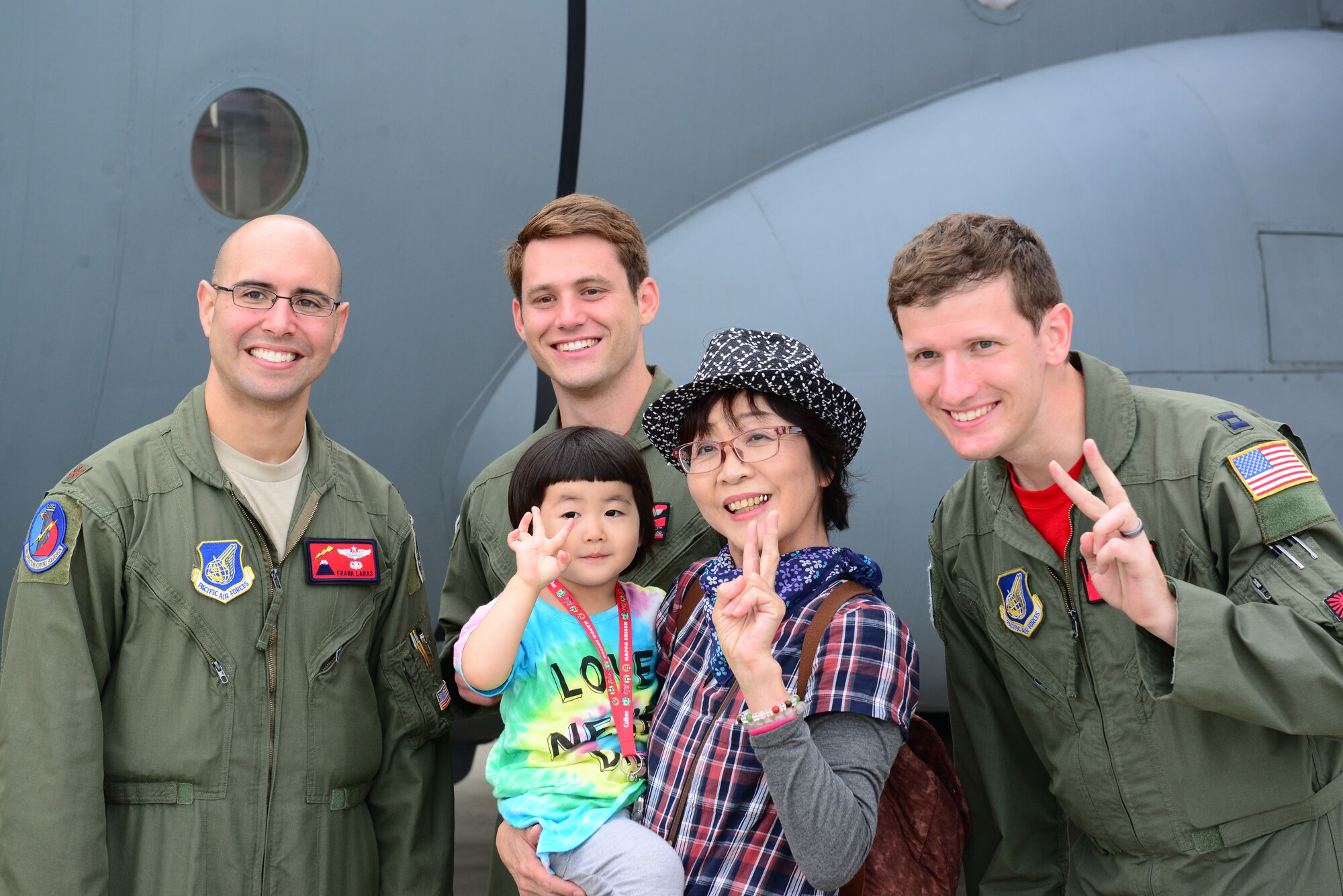 U.S. Air Force Major Frank Laras, 36th Airlift Squadron navigator (left), 1st Lt. Brendan Taylor 36th AS pilot (center) and Capt. Stephen Elliott 36th AS pilot (right), pose for a photo with Misawa Air Festival attendees. Airmen from the 459th Airlift Squadron and 36th Airlift Squadron Yokota Air Base participated in the Air Festival interacting with and teaching the local community about the aircraft. (U.S. Air Force photo by Tech. Sgt. Melissa Mekpongsatorn/Released)