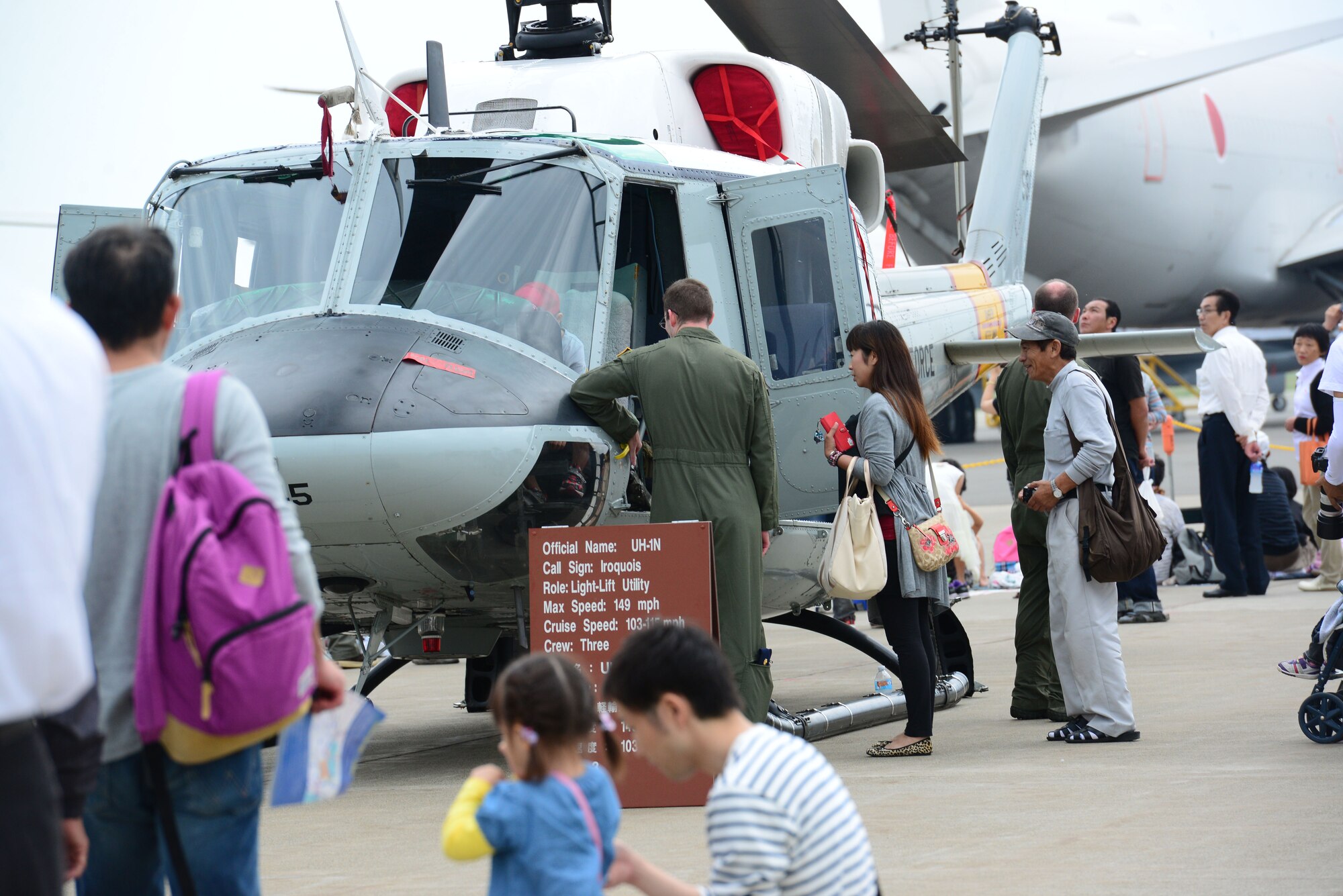 Spectators take a look at the UH-1N Iroquois helicopter at the Misawa Air Festival Sept. 13, 2015. Despite the rainy weather more than 100,000 people came out to the festival to experience the static displays, aerial demonstrations, live music and various types of food. (U.S. Air Force photo by Tech. Sgt. Melissa Mekpongsatorn/Released) 