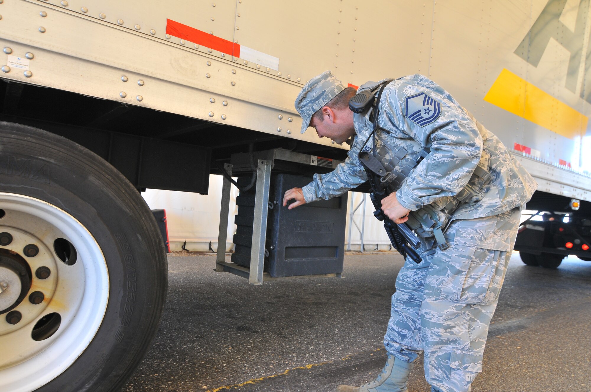 A picture of U.S. Air Force Master Sgt. Ryan Butcher, civil engineer, with the New Jersey Air National Guard's 177th Fighter Wing, inspecting a commercial vehicle entering the Atlantic City Air National Guard Base.