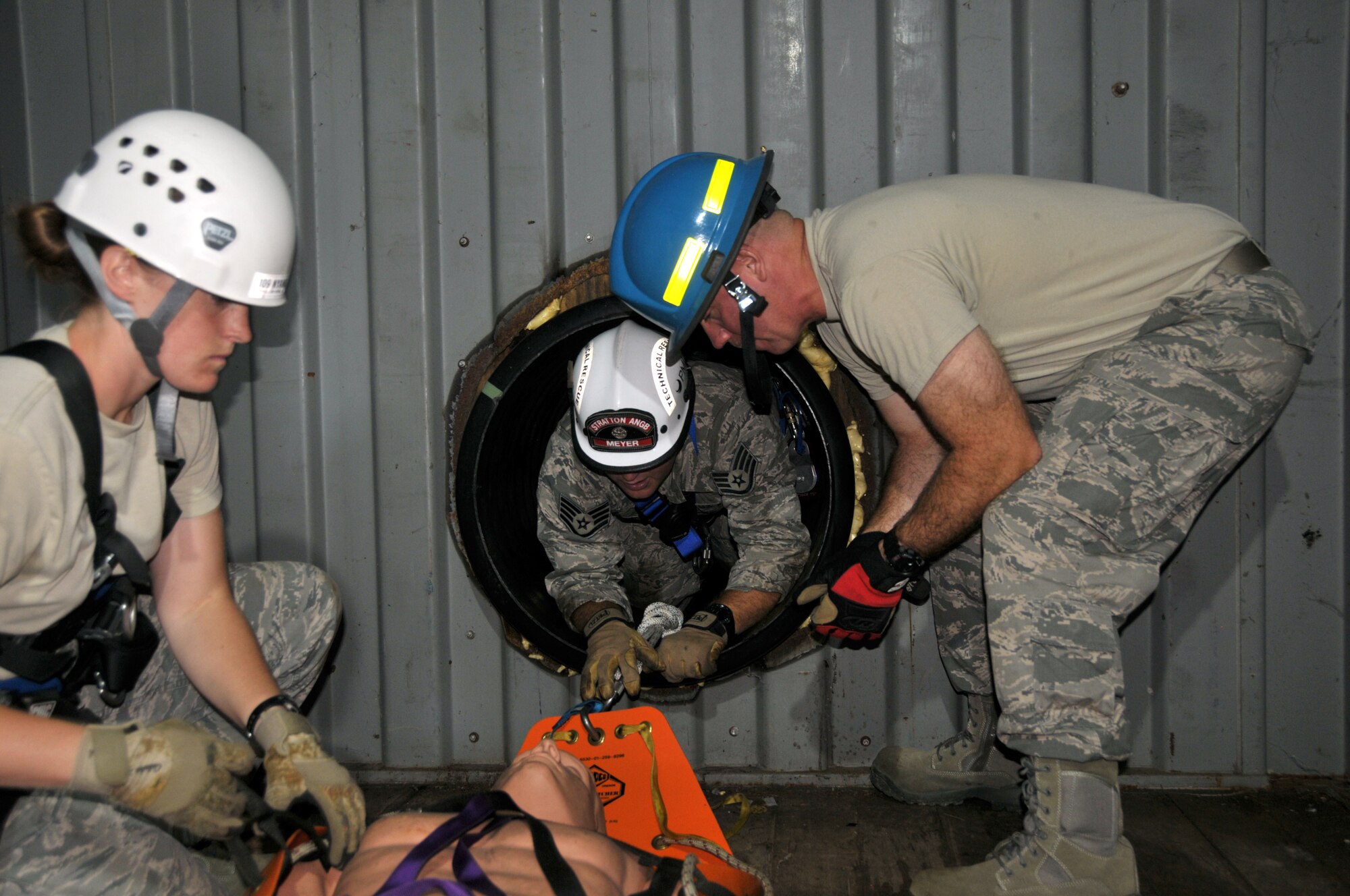 Staff Sgt. Jennifer Bristol and Staff Sgt. Christopher Meyer (center) rescue a victim as Tech. Sgt. Brian Kissinger (right) assists during confined space training for the 109th Fire Department's search and rescue team at Stratton Air National Guard Base, New York, on Sept. 17, 2015. The 12-person search and rescue team trains monthly on various rescue techniques. (U.S. Air National Guard photo by Tech. Sgt. Catharine Schmidt/Released)
