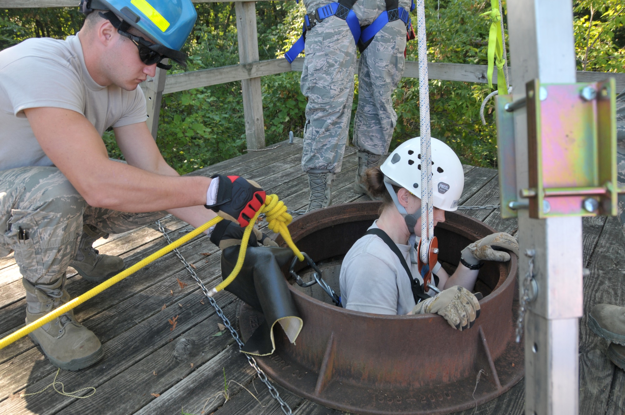 Senior Airman James Olson helps lower Staff Sgt. Jennifer Bristol during confined space training for the 109th Fire Department's search and rescue team at Stratton Air National Guard Base, New York, on Sept. 17, 2015. The 12-person search and rescue team trains monthly on various rescue techniques. (U.S. Air National Guard photo by Tech. Sgt. Catharine Schmidt/Released)
