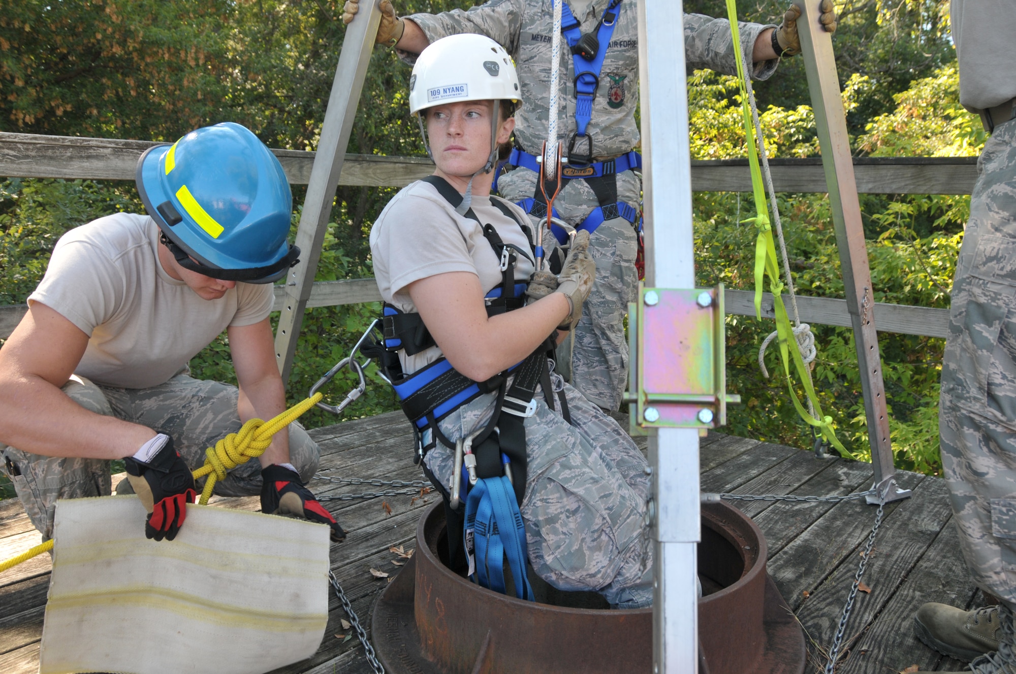 The 109th Fire Department's search and rescue team prepare to lower Staff Sgt. Jennifer Bristol during confined space training for the team at Stratton Air National Guard Base, New York, on Sept. 17, 2015. The 12-person search and rescue team trains monthly on various rescue techniques. (U.S. Air National Guard photo by Tech. Sgt. Catharine Schmidt/Released)