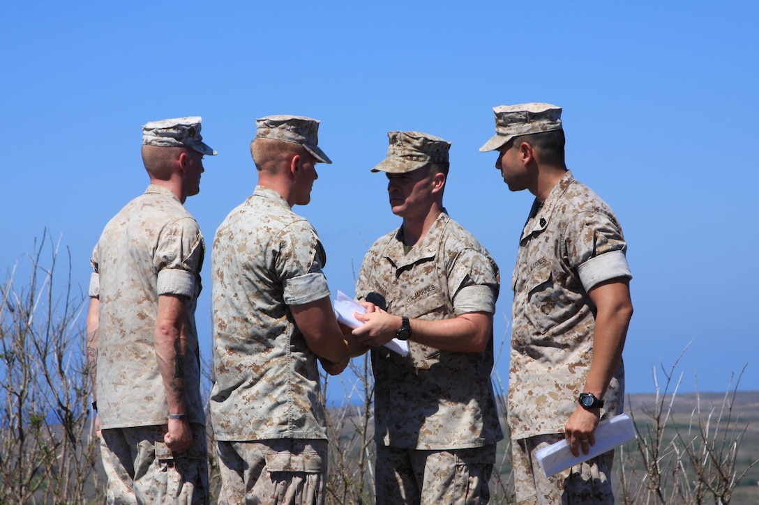 Assault Amphibian Vehicle Company Marines Cpl. Joseph D. Blanton III and SSgt. Mikael B. Everett are awarded the Navy and Marine Corps Achievement Medal by Company Commander Maj. Timothy Riemann on Sept. 2 atop Mount Suribachi, Iwo Jima. AAV Company Marines are part of Task Force Iron Fist 4 out of Camp Fuji, Japan.