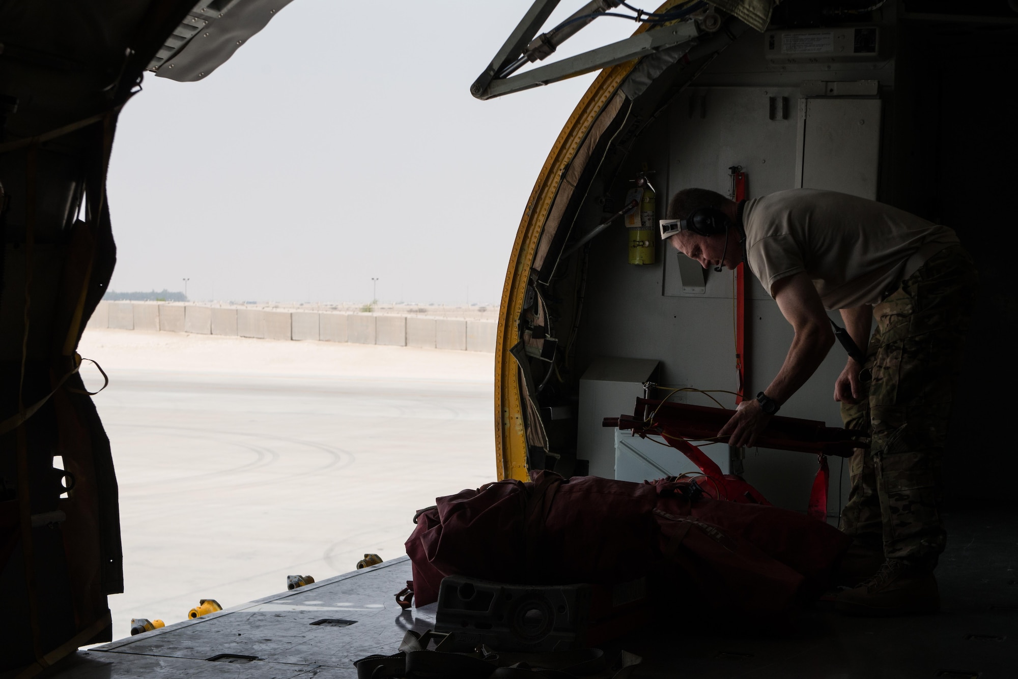 Senior Master Sgt.  Barry, 340th Expeditionary Air Refueling Squadron boom operator, stacks a ladder used to enter the aircraft as he completes his checklist prior to takeoff September 16, 2015 at Al Udeid Air Base, Qatar. (U.S. Air Force photo/Staff Sgt. Alexandre Montes)