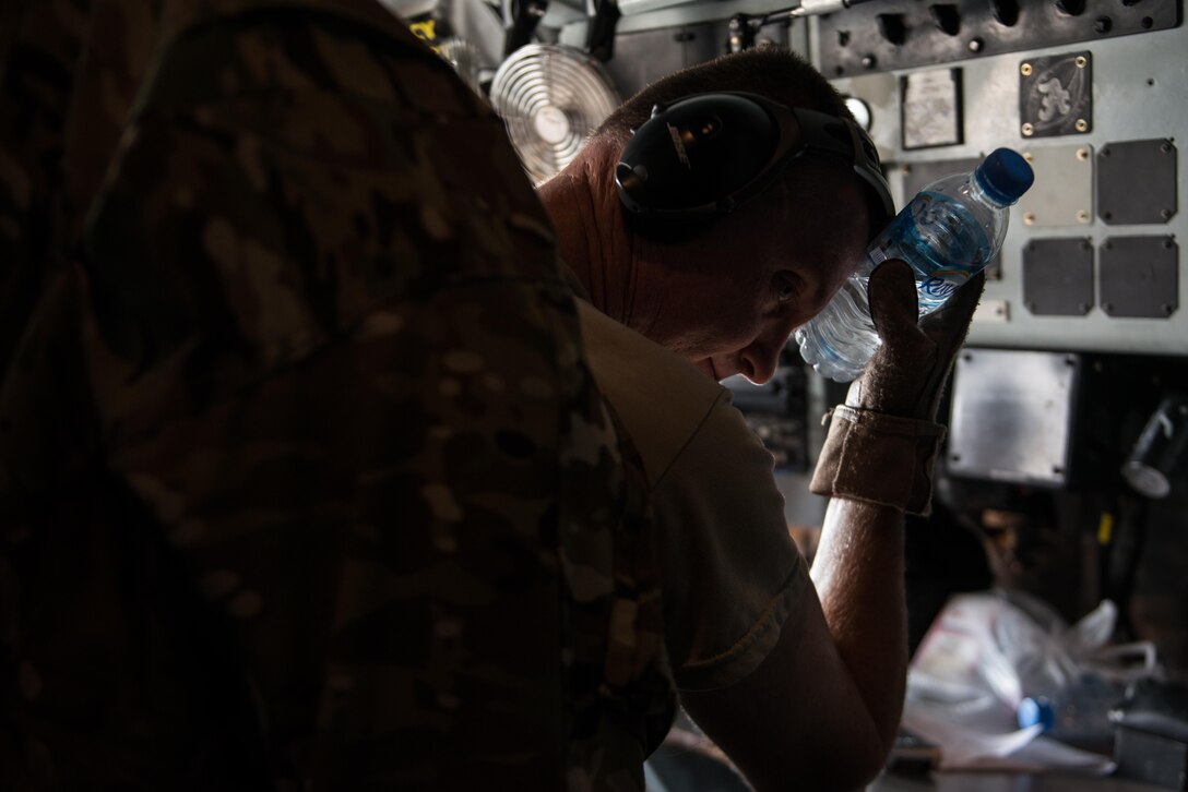 Senior Master Sgt.  Barry, 340th Expeditionary Air Refueling Squadron boom operator, cools himself with a cold water bottle waiting for the aircraft’s internal temperature to lower from 105 degrees September 16, 2015 at Al Udeid Air Base, Qatar. (U.S. Air Force photo/Staff Sgt. Alexandre Montes) 